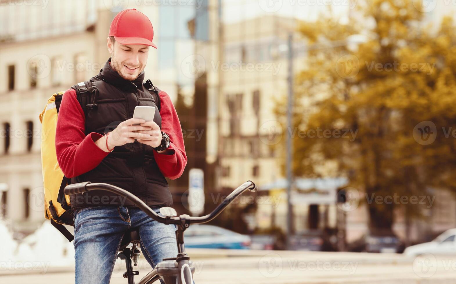 Courier Using Delivery Application On Smartphone Delivering Restaurant Food On Bicycle In City. Free Space For Text photo