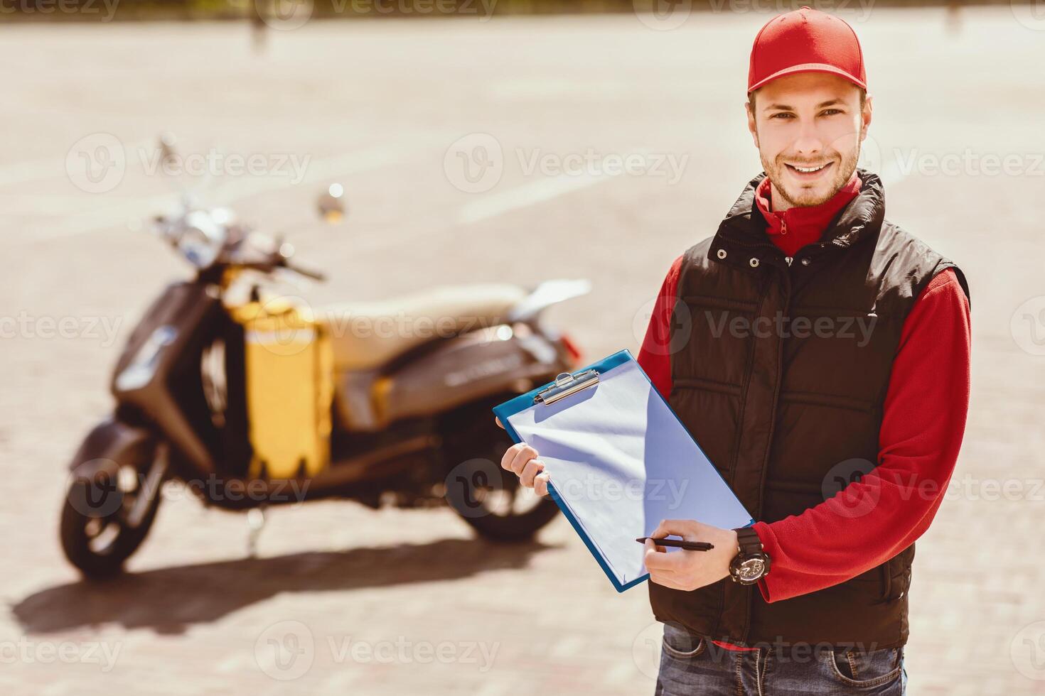 Courier Career. Delivery Man In Uniform Holding Folder Offering Delivering Services Standing Near Motorbike Outdoor. Copy Space photo