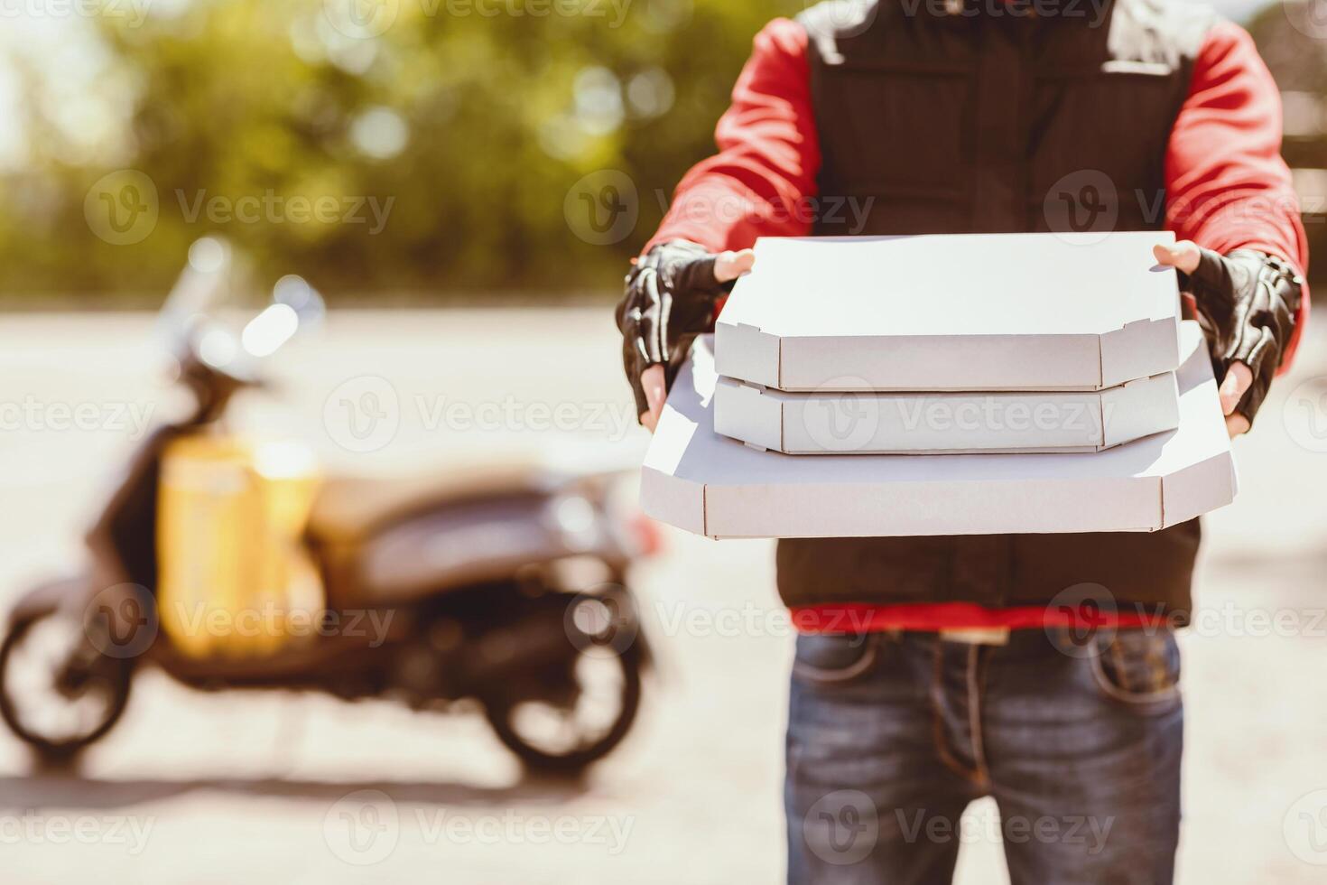Pizza Delivery. Unrecognizable Courier Offering Pizzas Boxes To Camera Standing Outdoor. Cropped, Empty Space photo