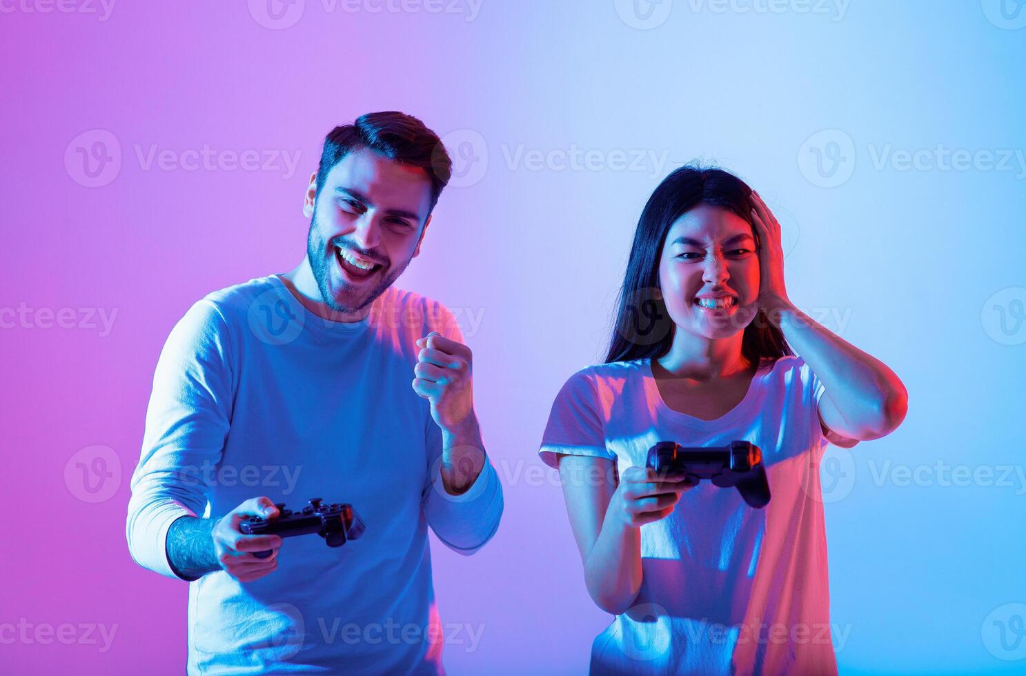 Two friends enjoy a gaming session, immersed in colorful lighting. Their expressions show excitement and joy as they compete in a game together during the evening. photo