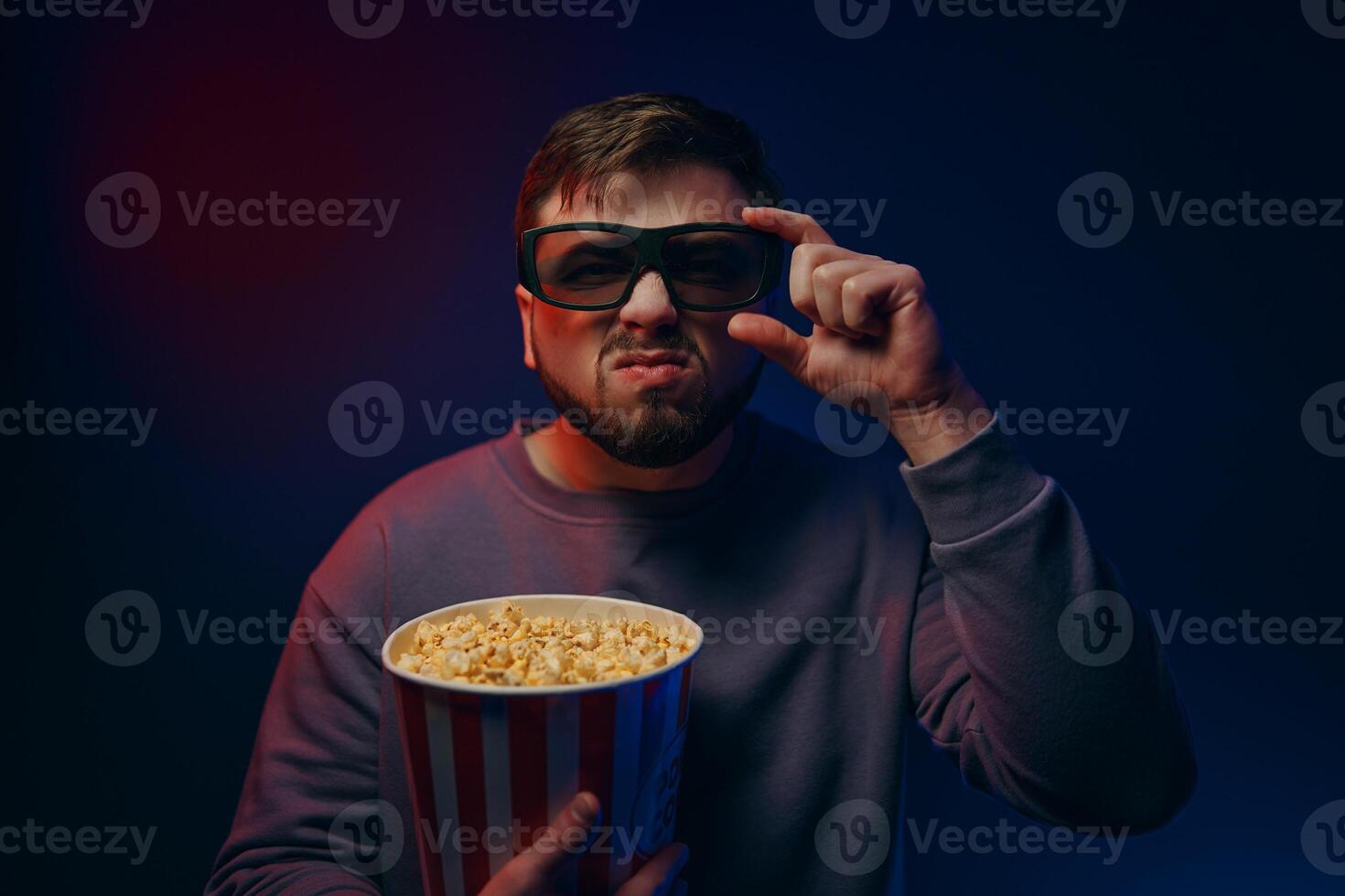 Watching a movie at home. A man watches a movie with a surprised expression on his face. photo