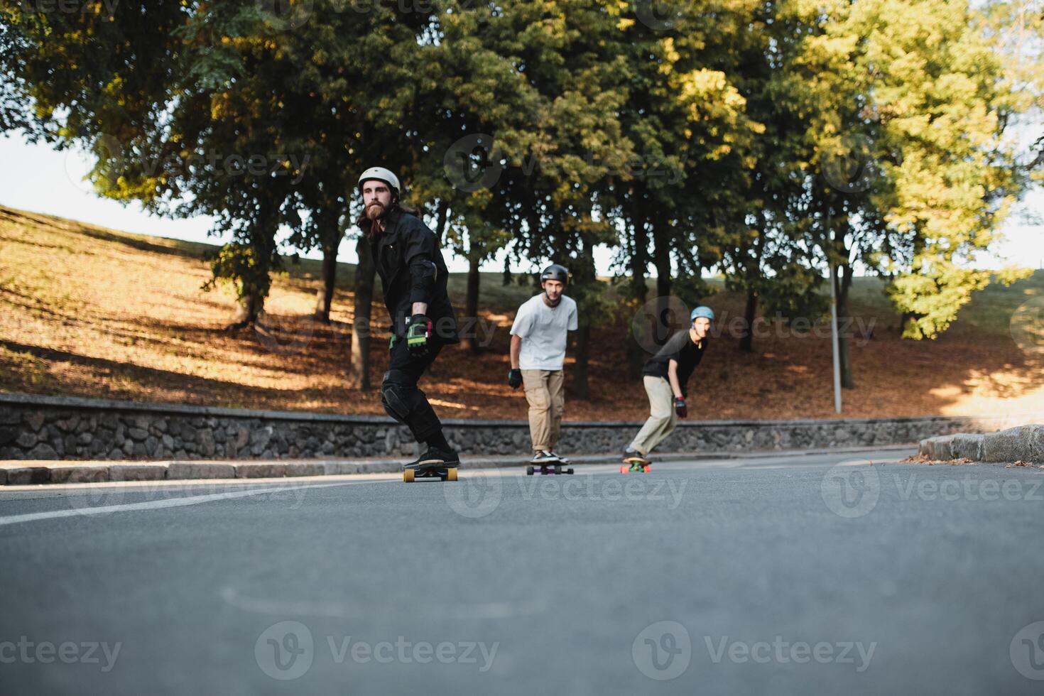 Three charismatic guys ride longboards. photo