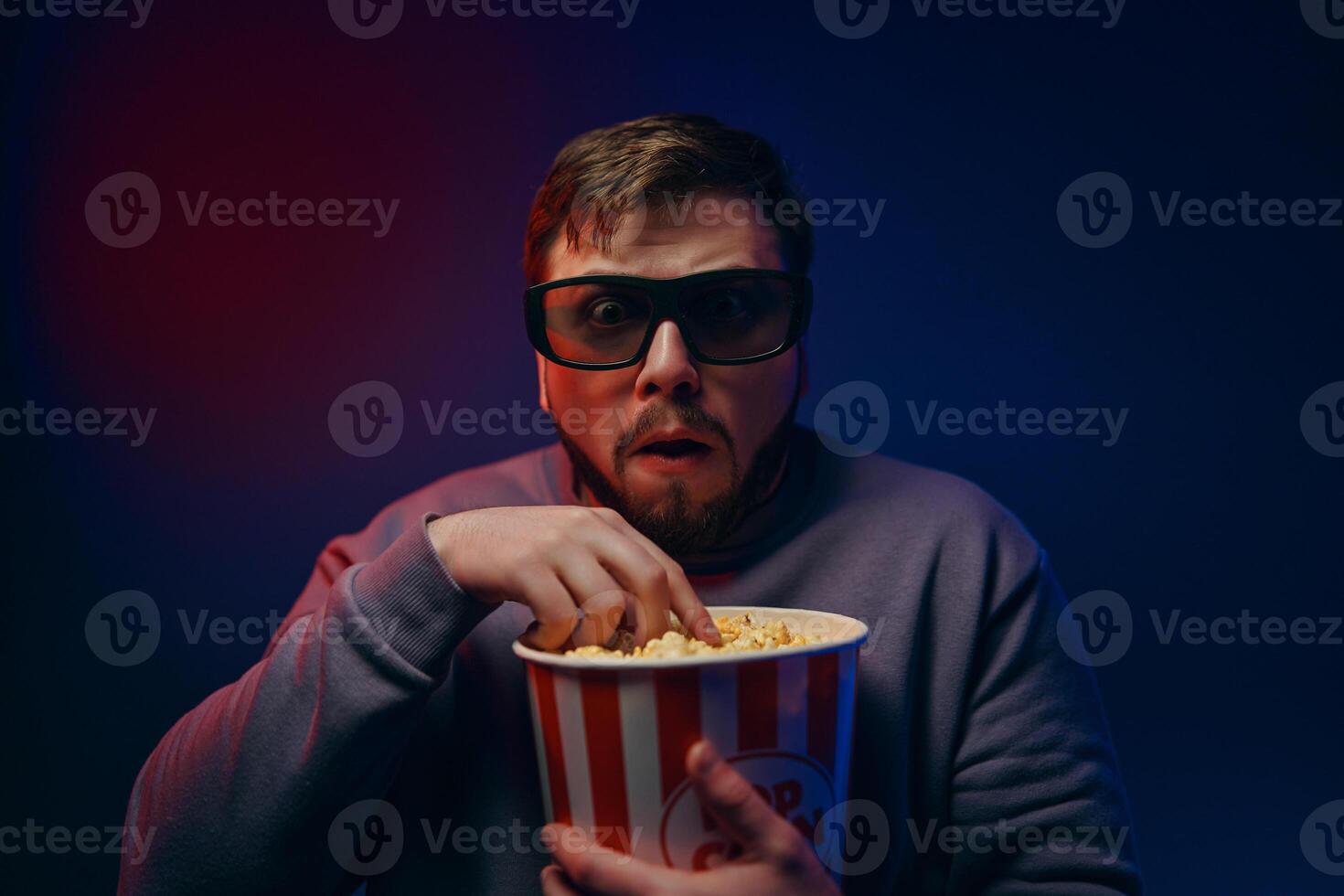 A man watches horror movies. The emotion of fear. photo