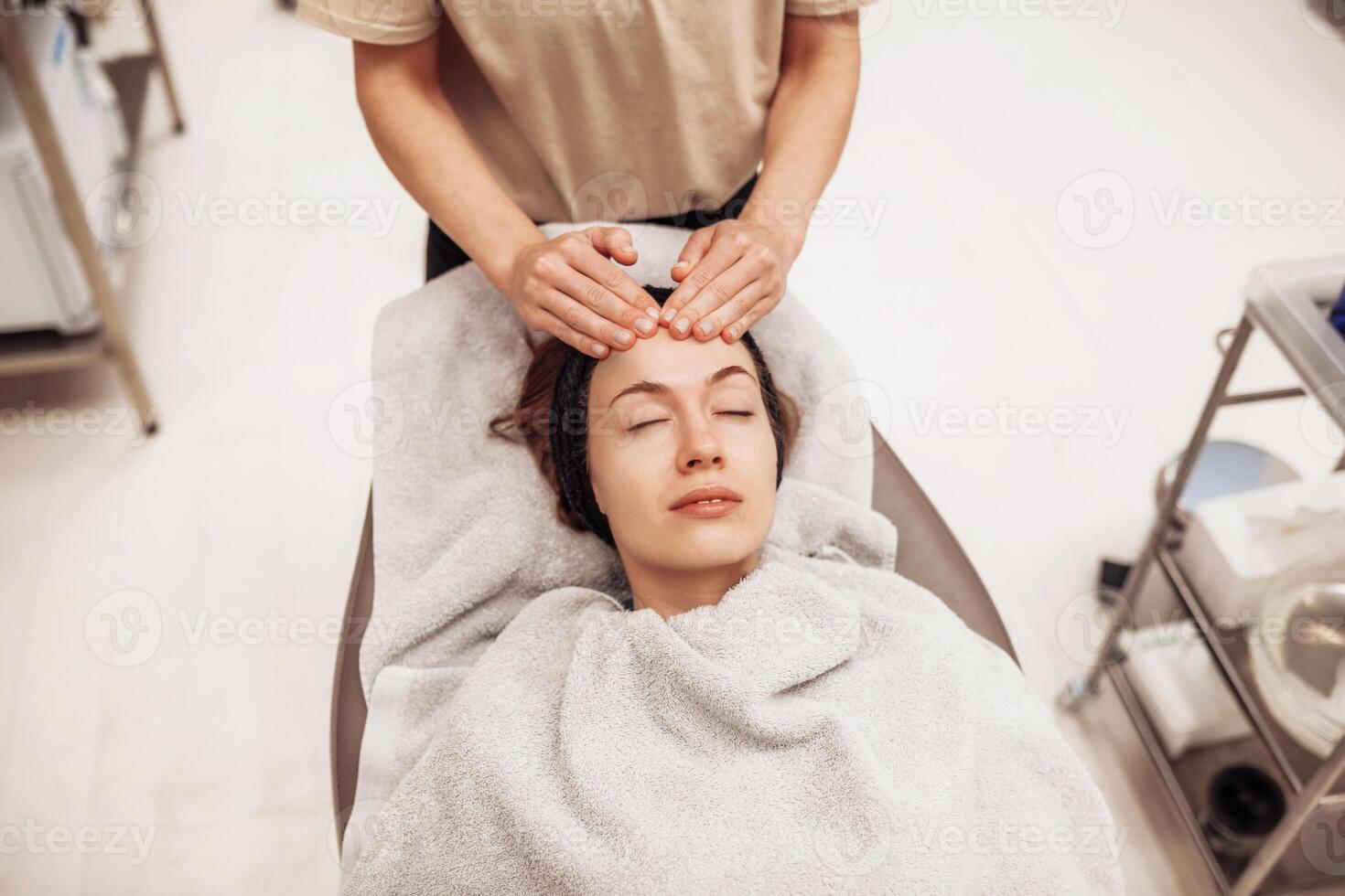 Woman receiving facial massage in beauty salon. photo