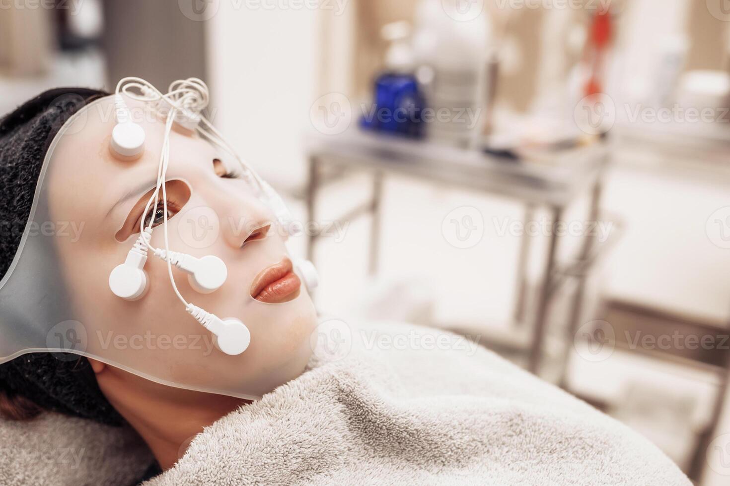 Woman receiving facial massage in beauty salon. photo