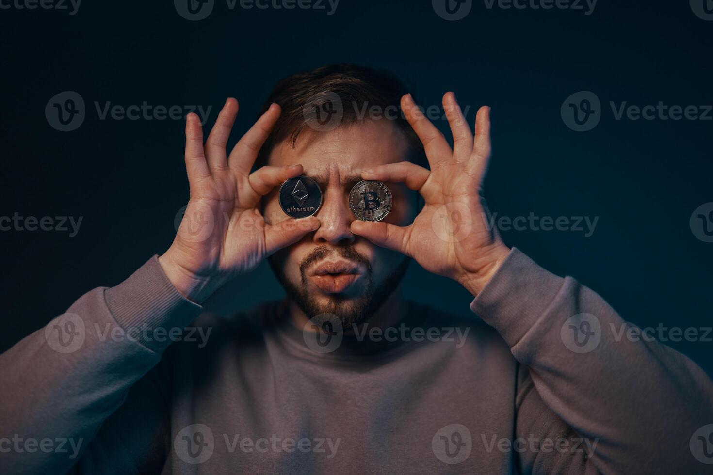 A young man with a bitcoin in his hands. Cryptocurrency. photo