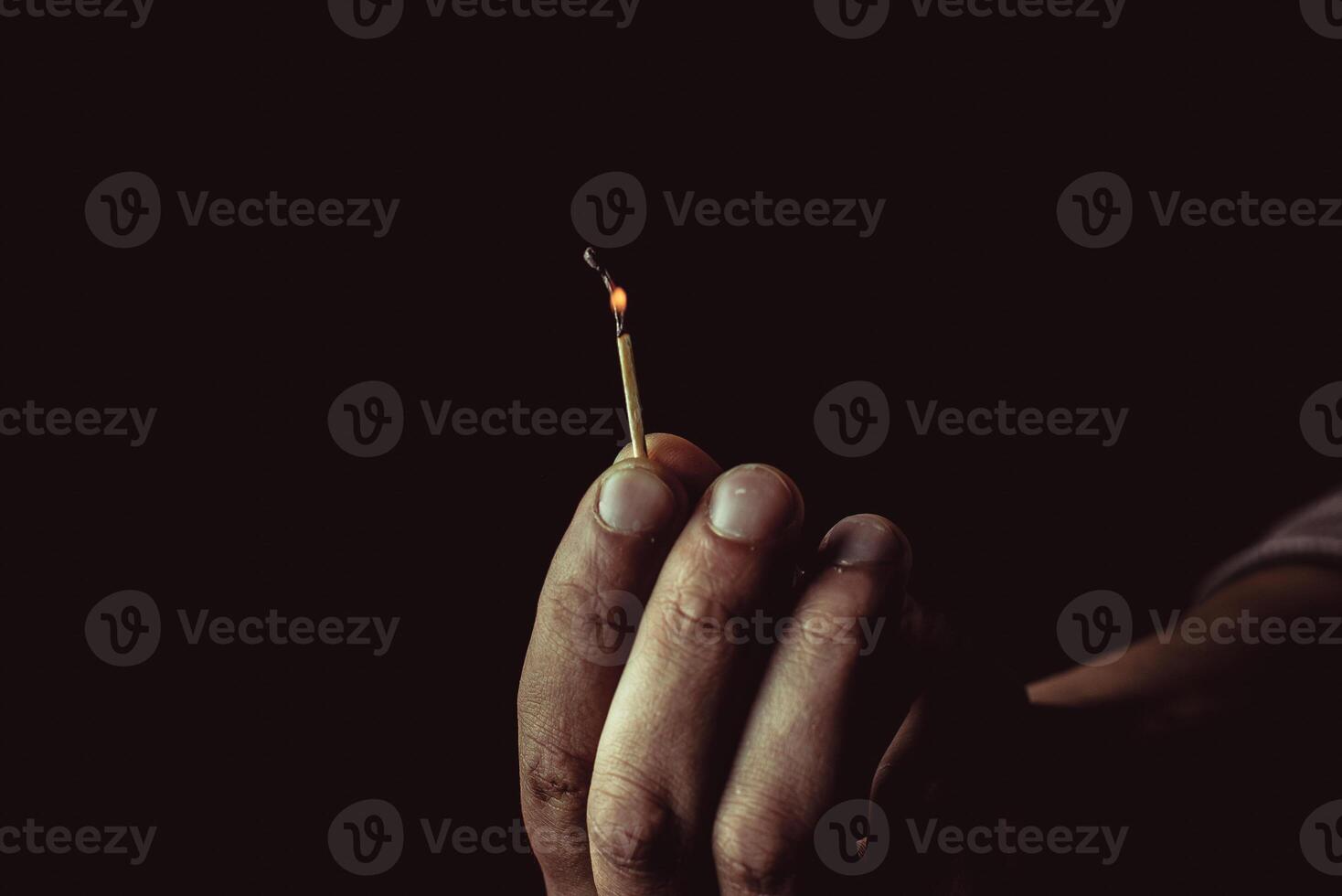 Burning match in the man's hand. Dangerous game with fire. photo