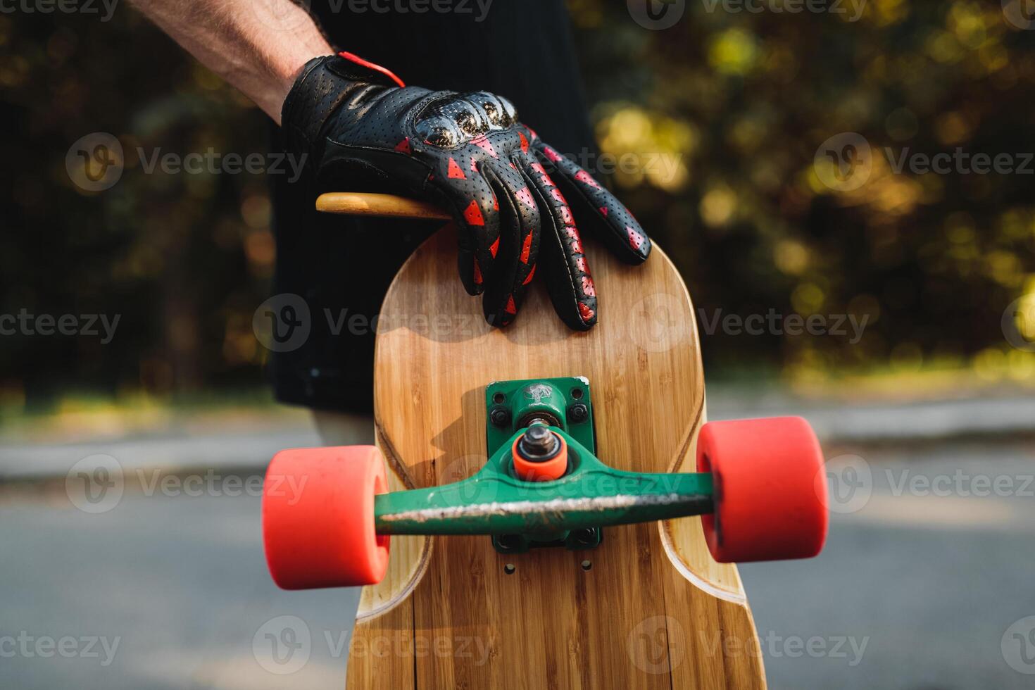 The guy is holding a board with red wheels. Skateboarding in the eternal city. photo