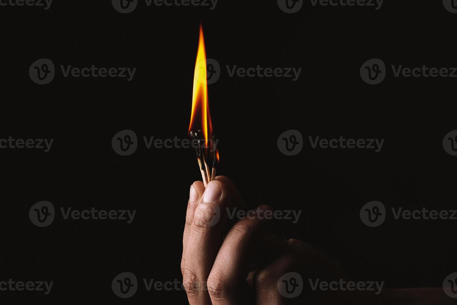 Burning match in the man's hand. Dangerous game with fire. photo