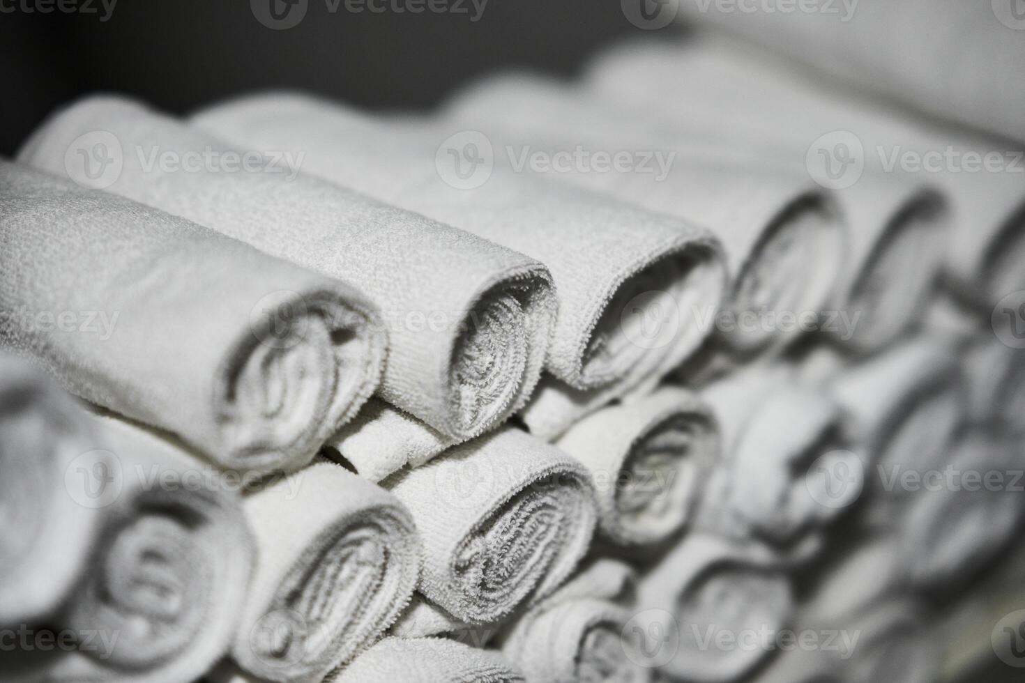 Rolled white towels stacked in a spa for relaxation and comfort photo
