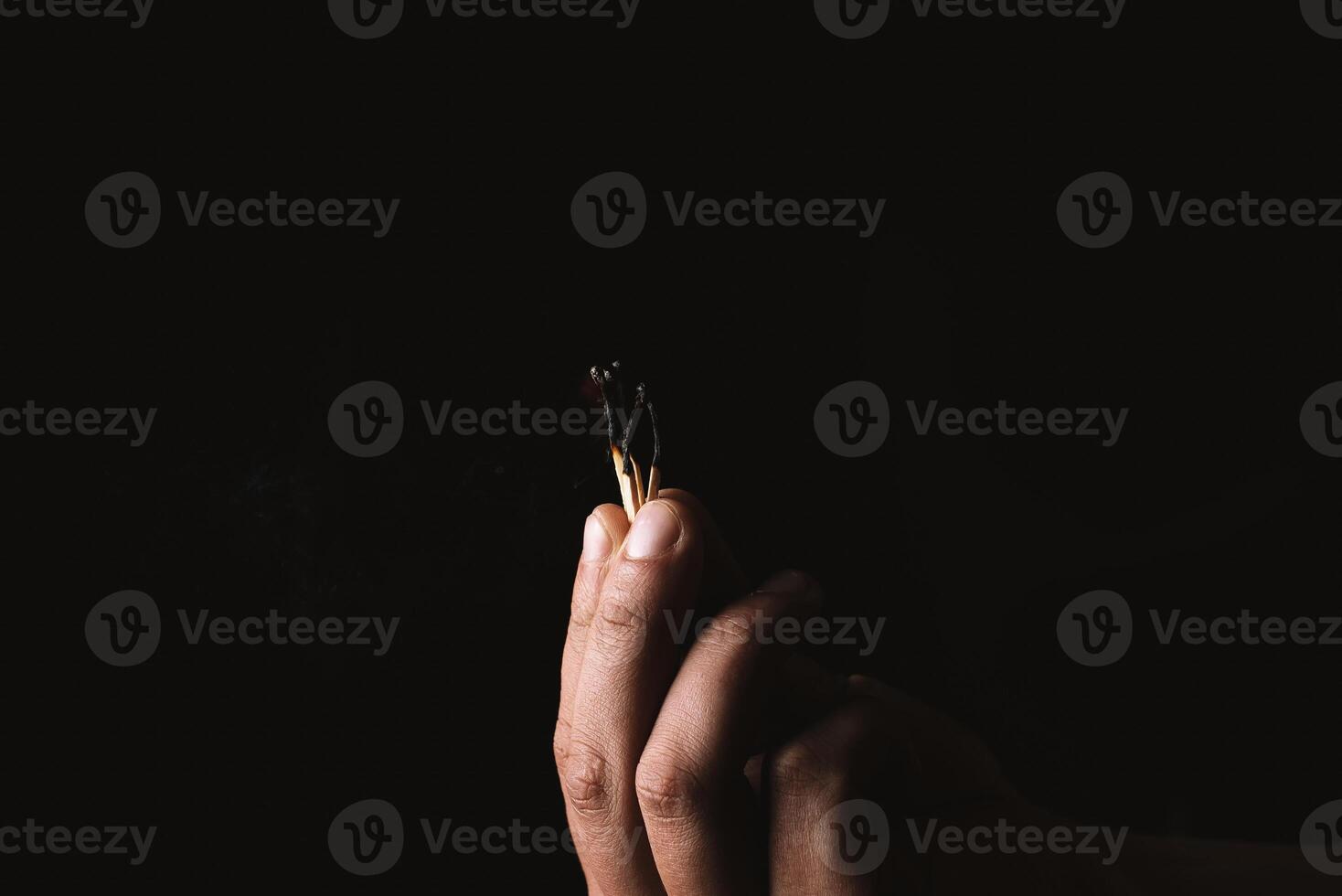 Burning match in the man's hand. Dangerous game with fire. photo