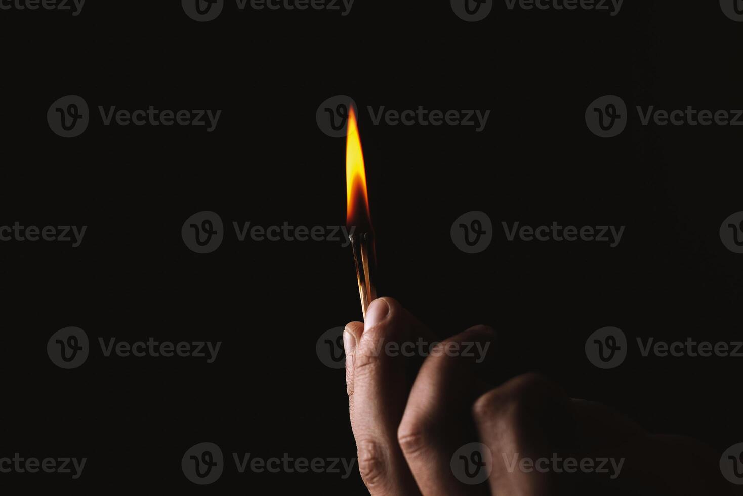 Burning match in the man's hand. Dangerous game with fire. photo