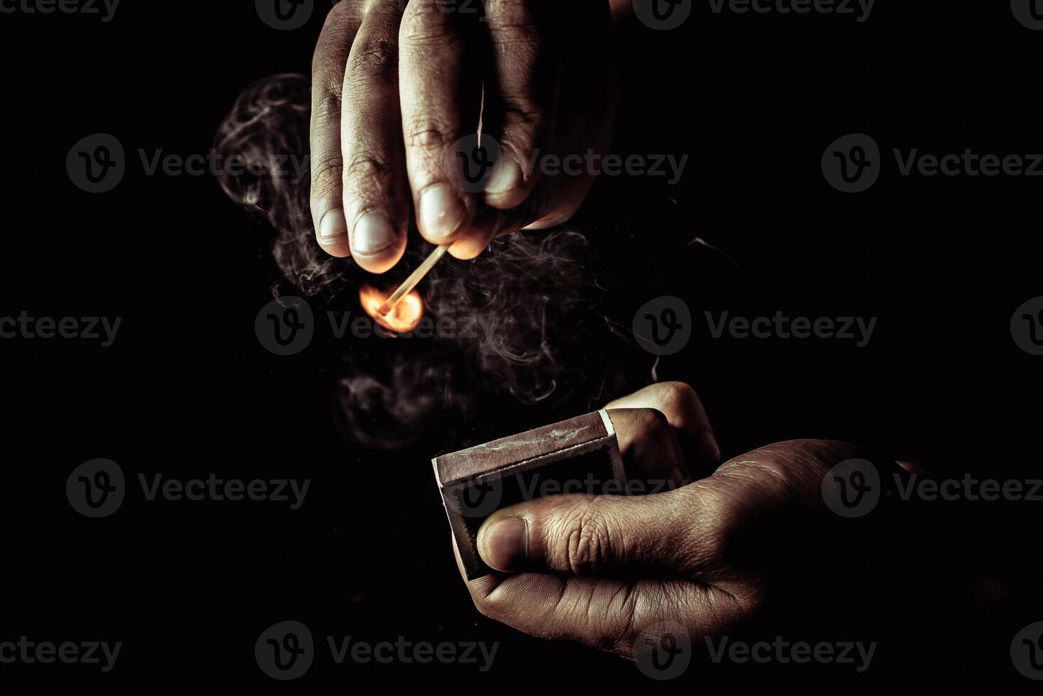 match in hand burns on dark background photo