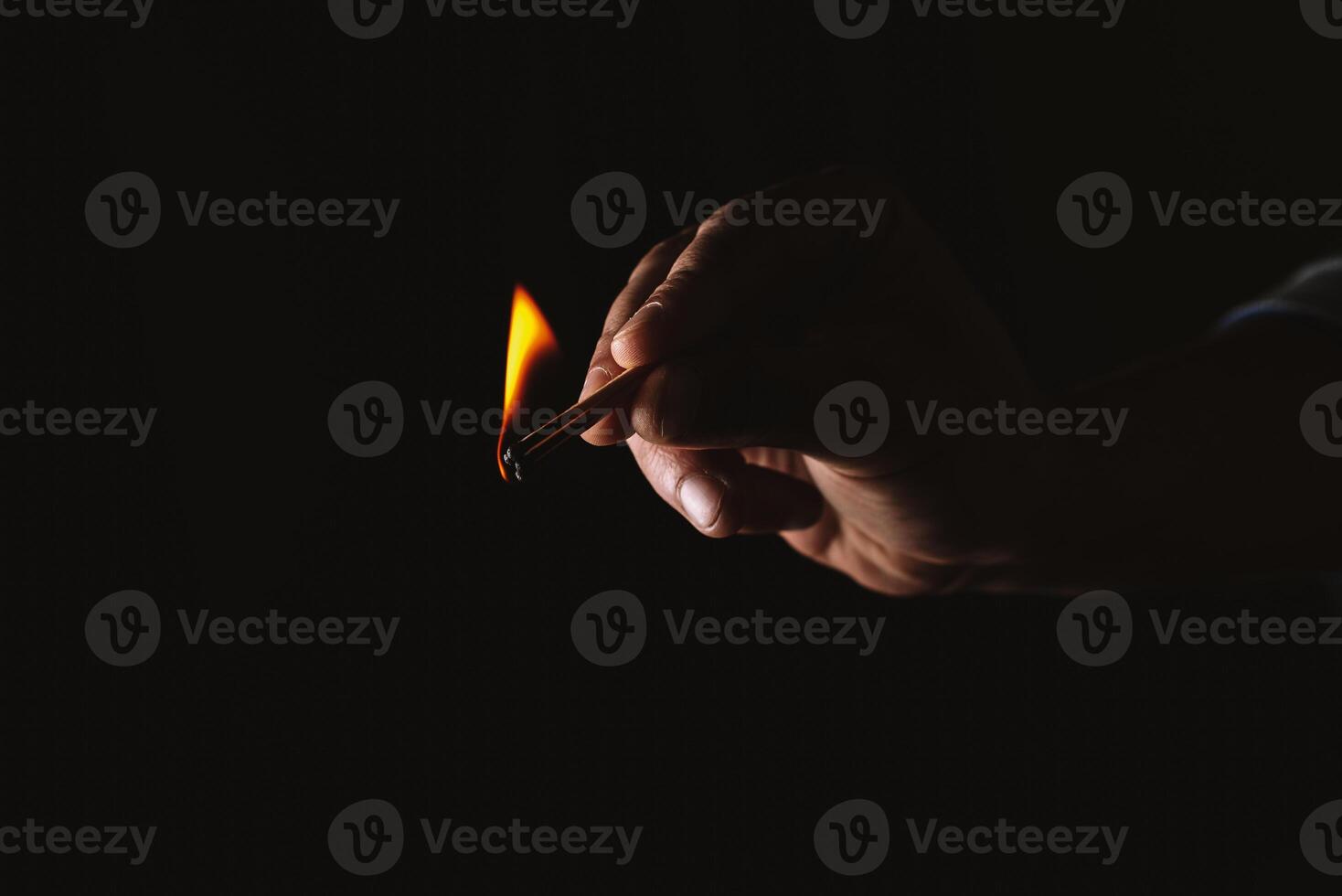 Burning match in the man's hand. Dangerous game with fire. photo