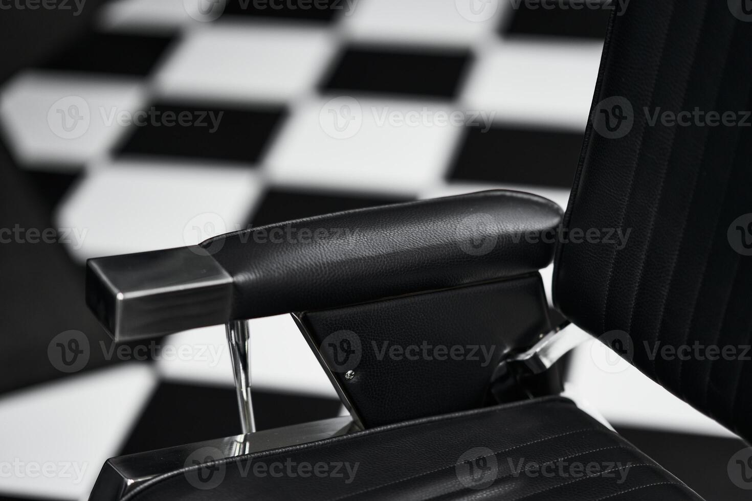 Black and white checkered floor with a modern barber chair at a salon photo