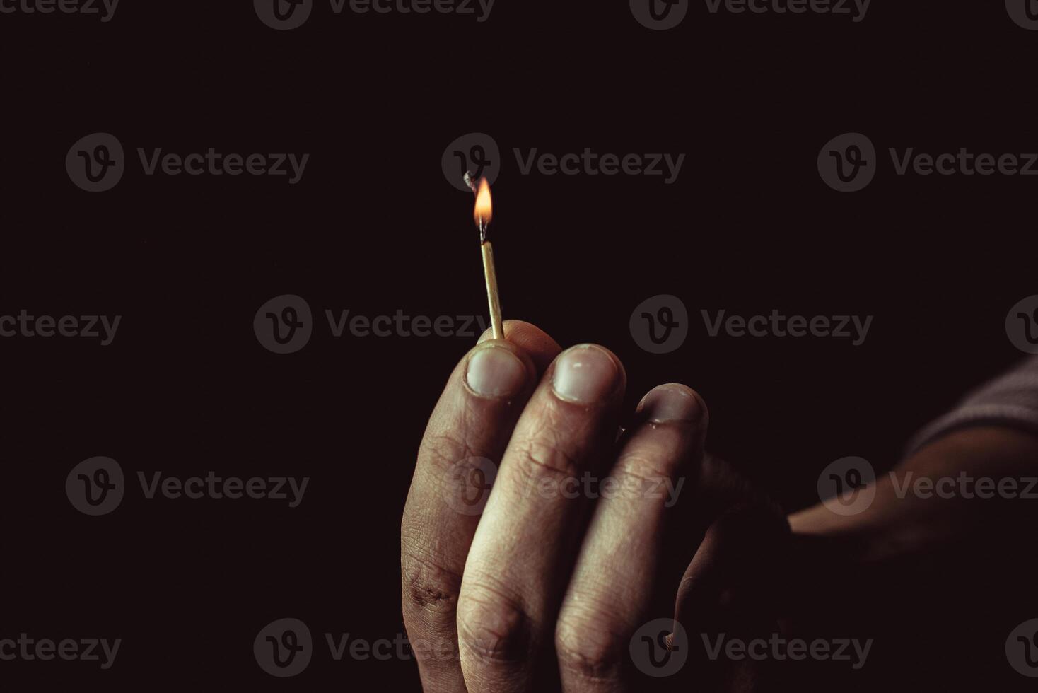 Burning match in the man's hand. Dangerous game with fire. photo