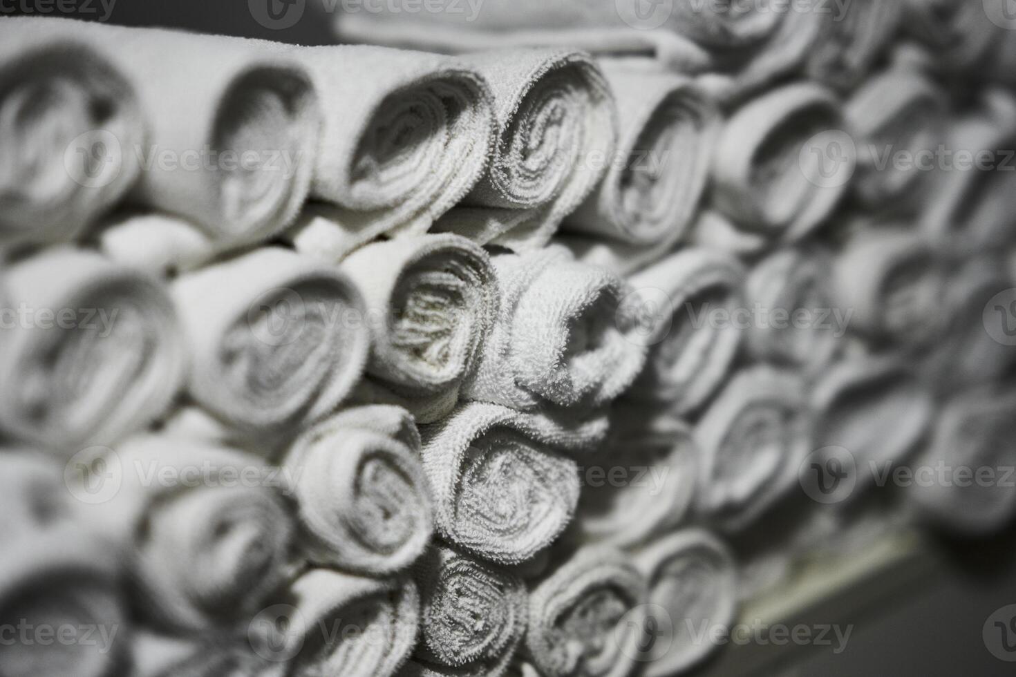 Neatly rolled white towels stacked in a clean facility during daytime photo