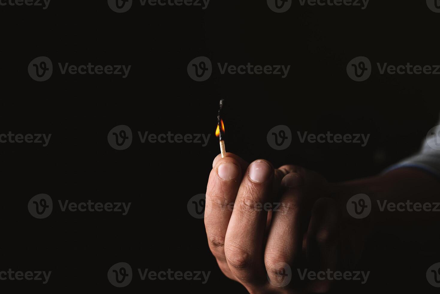 Burning match in the man's hand. Dangerous game with fire. photo