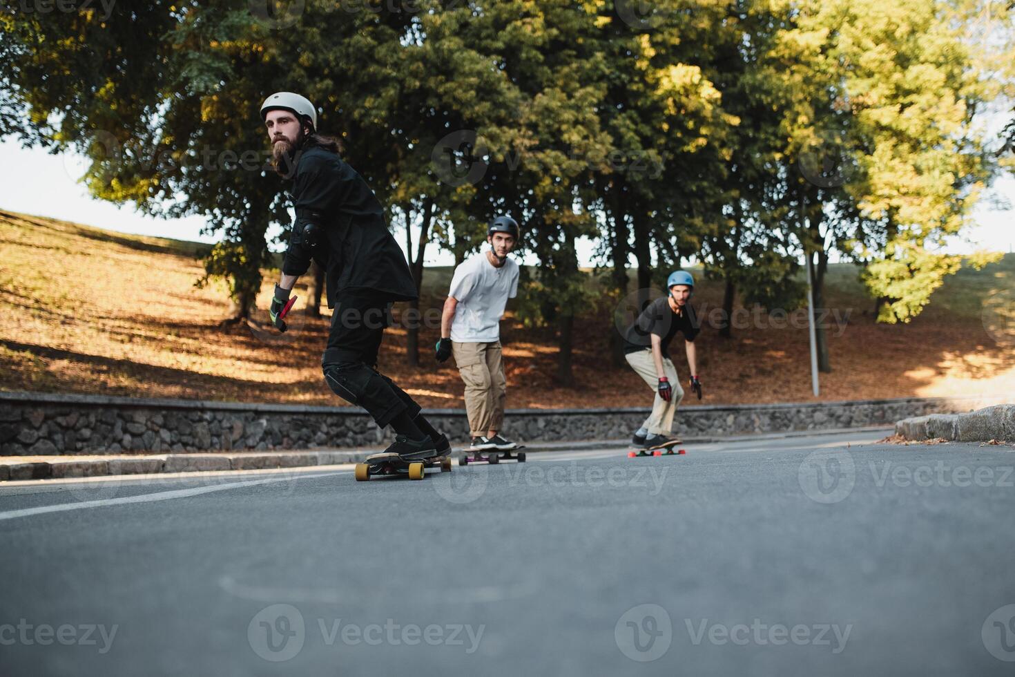 Three charismatic guys ride longboards. Bottom view. photo