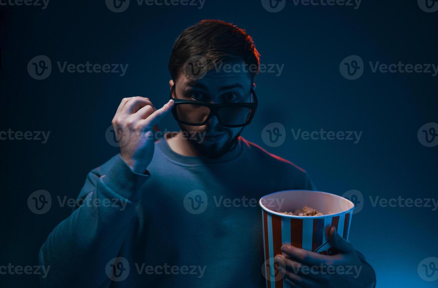 Man with surprised expression and popcorn. Emotion while watching a movie. photo