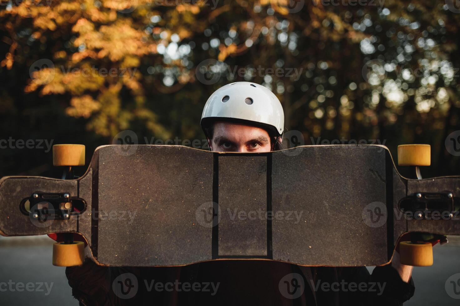 Man holding skate, longboard at sunset. photo