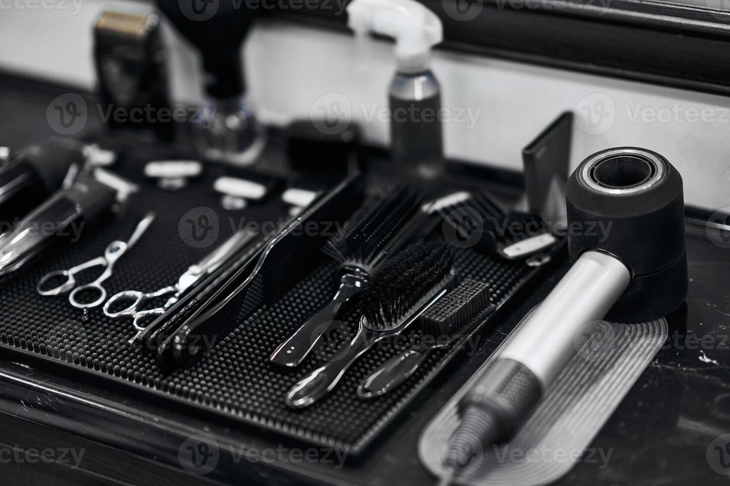 Hair salon tools neatly arranged on a black countertop at a barbershop photo