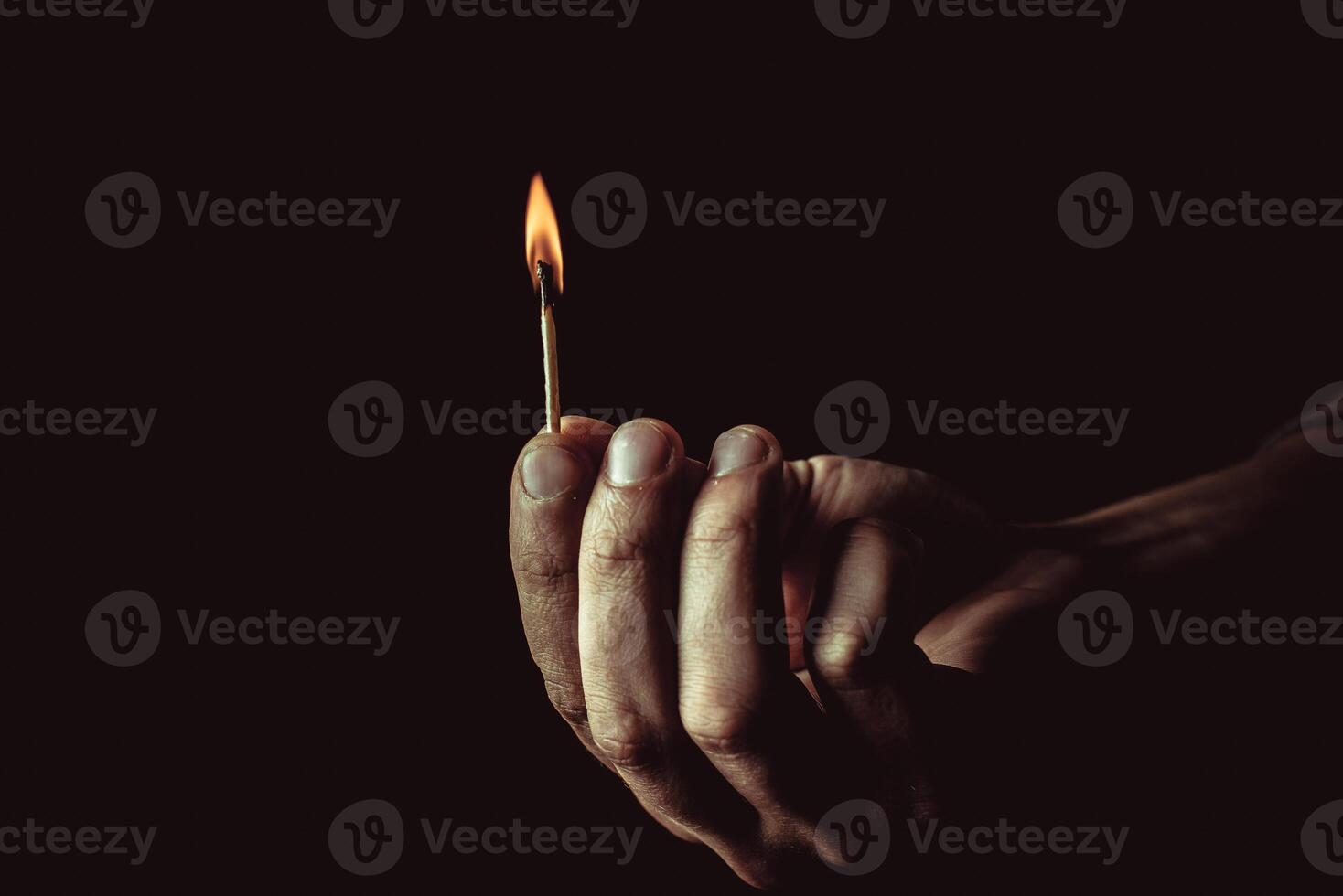 Burning match in the man's hand. Dangerous game with fire. photo