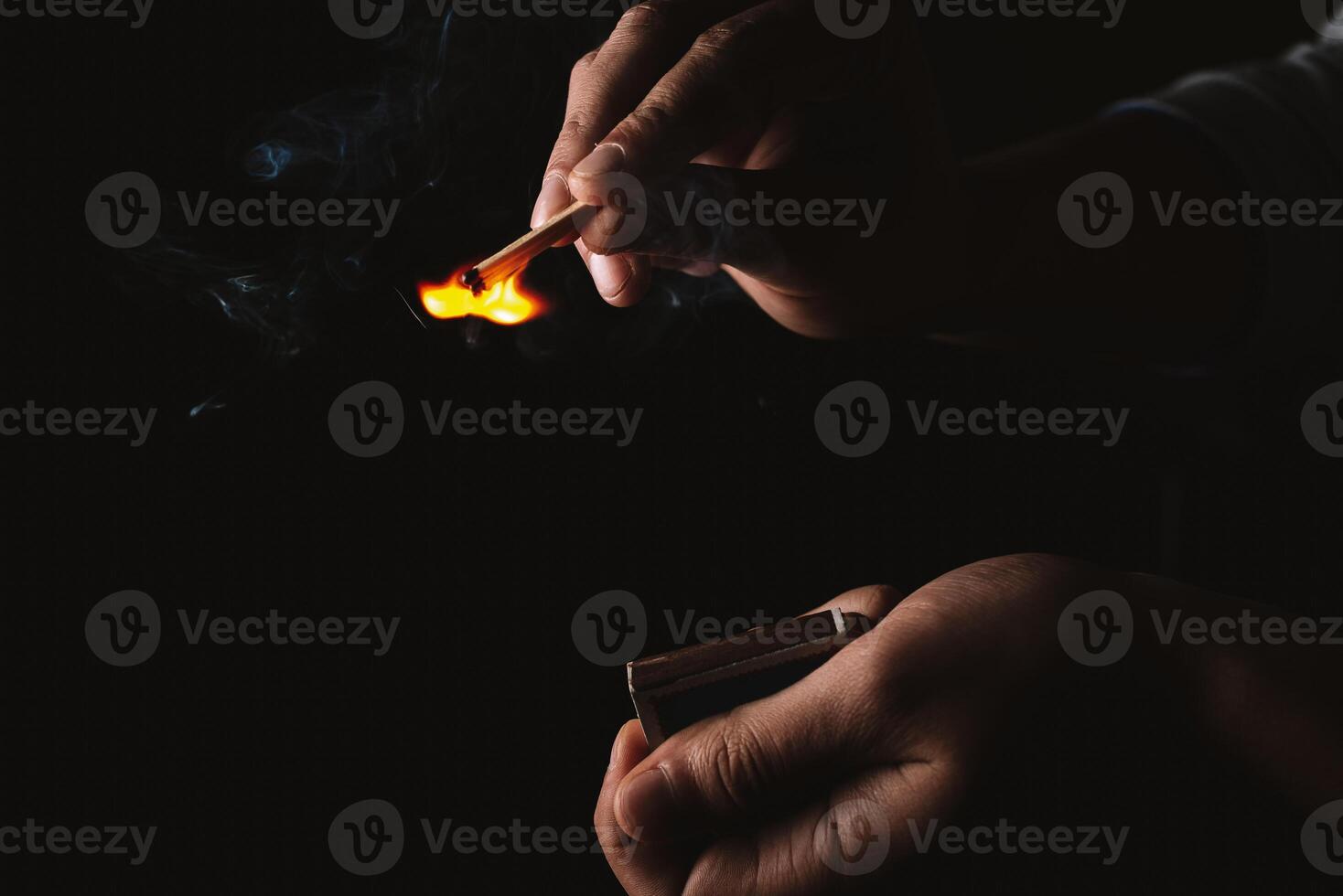 Burning match in the man's hand. Dangerous game with fire. photo