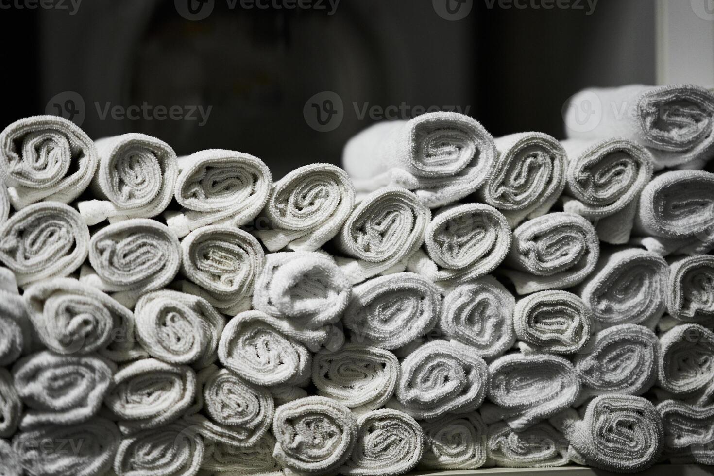 Neatly rolled white towels stacked for display in a spa environment photo