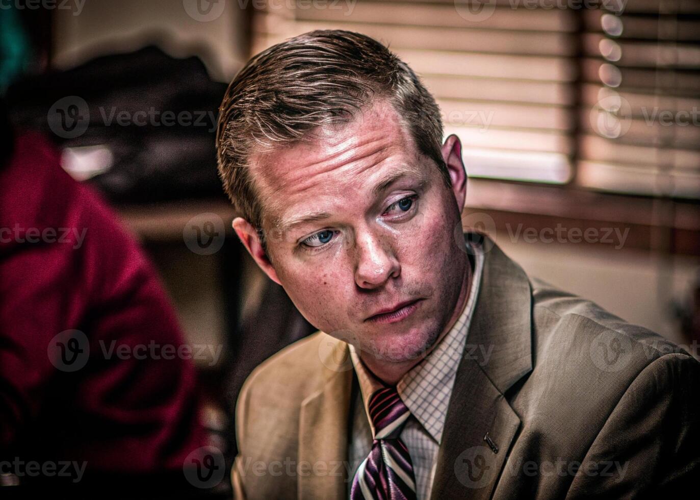 a man in a suit and tie sitting at a table photo