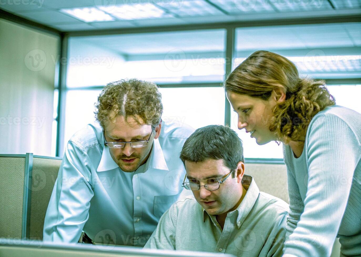 three people looking at a computer screen photo