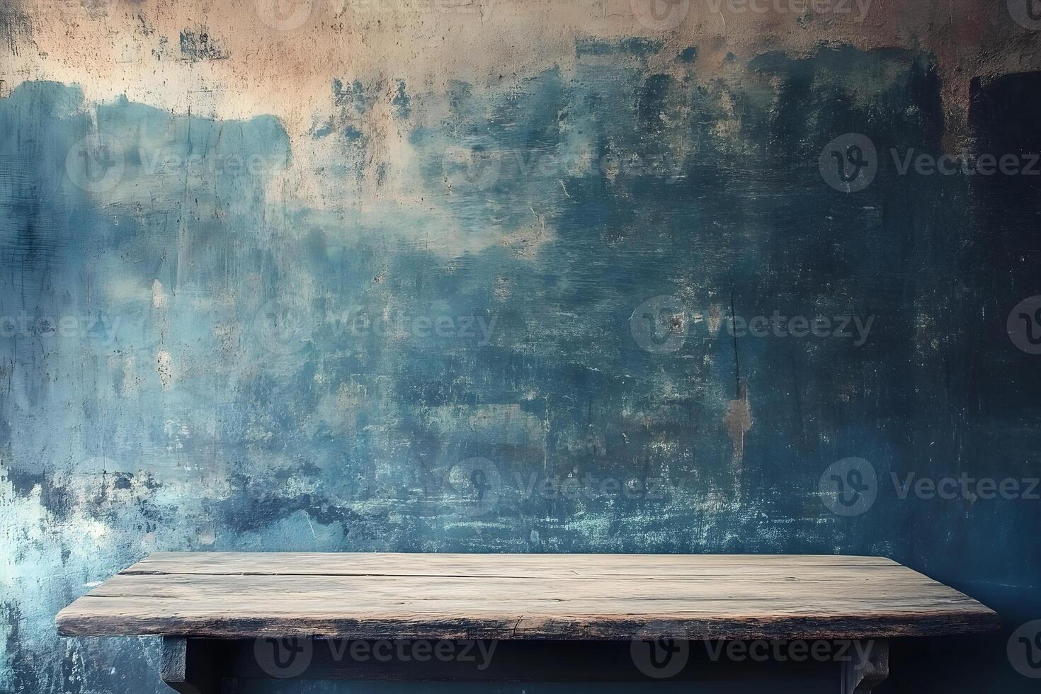 An empty wooden table against a blue wall photo