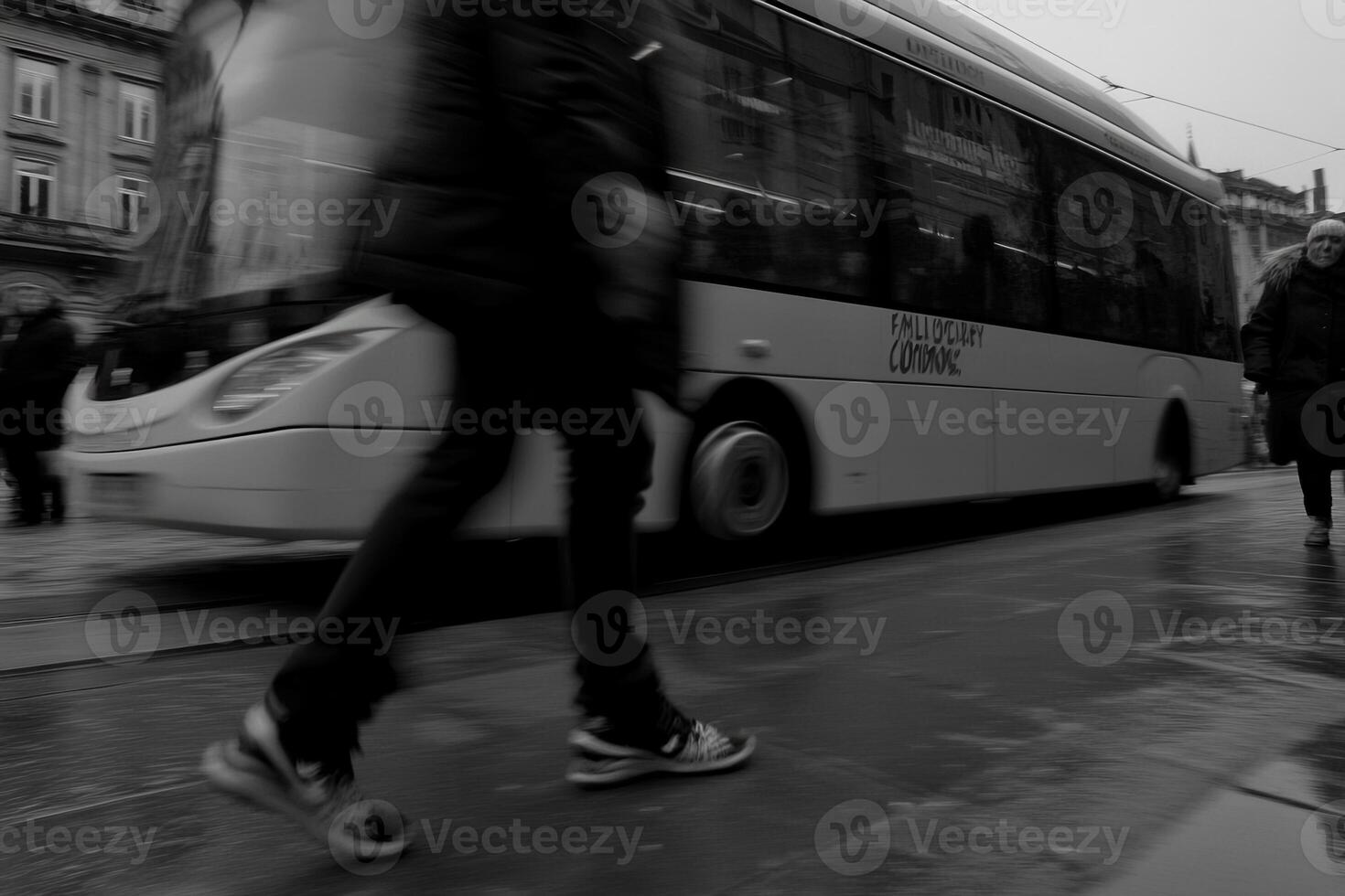 A blurred city scene with pedestrians and a bus. photo