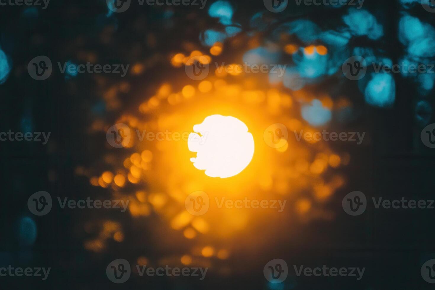 Blurred sunset through foliage creating a warm glow. photo