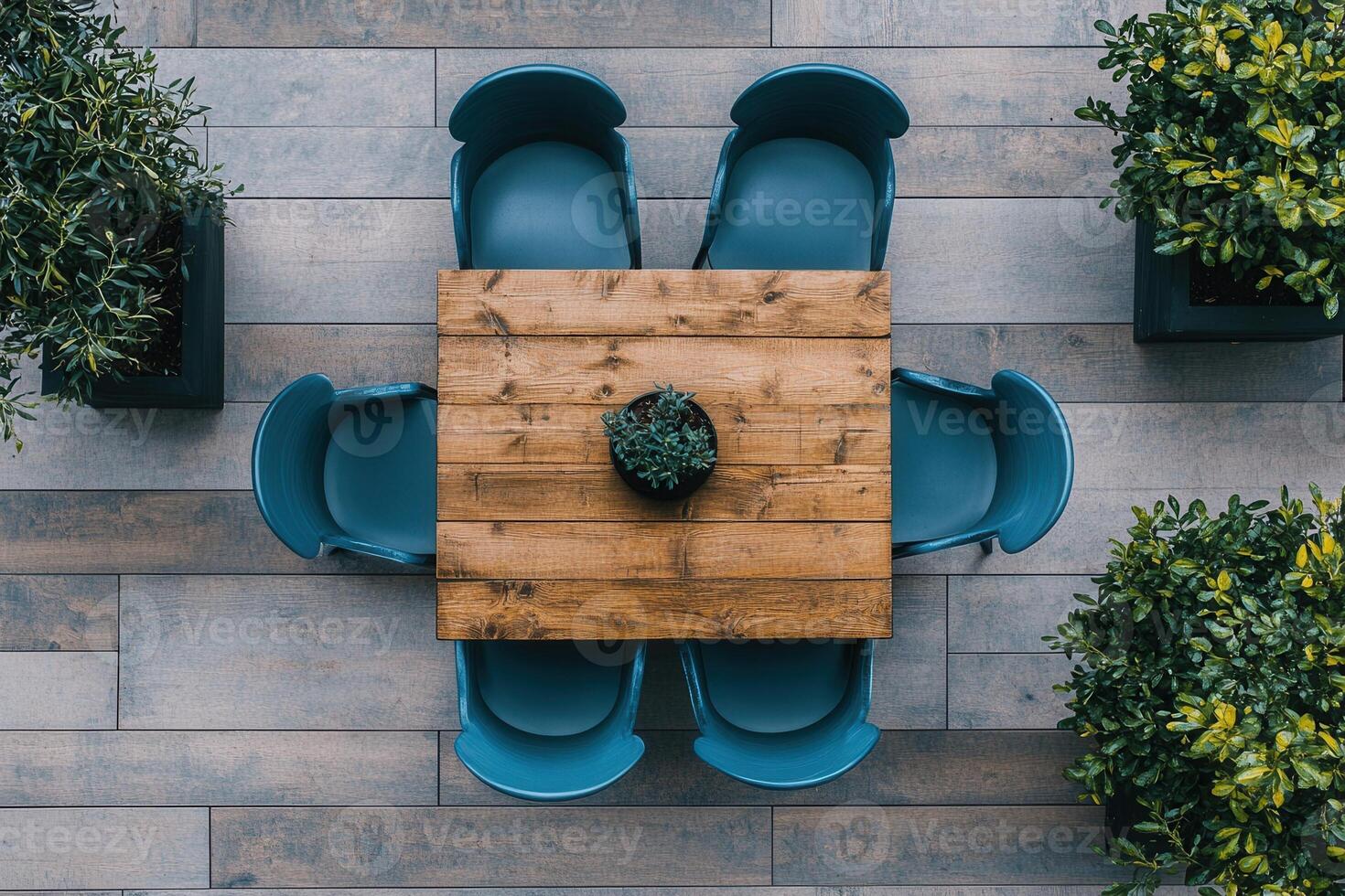 A wooden table surrounded by blue chairs and plants. photo