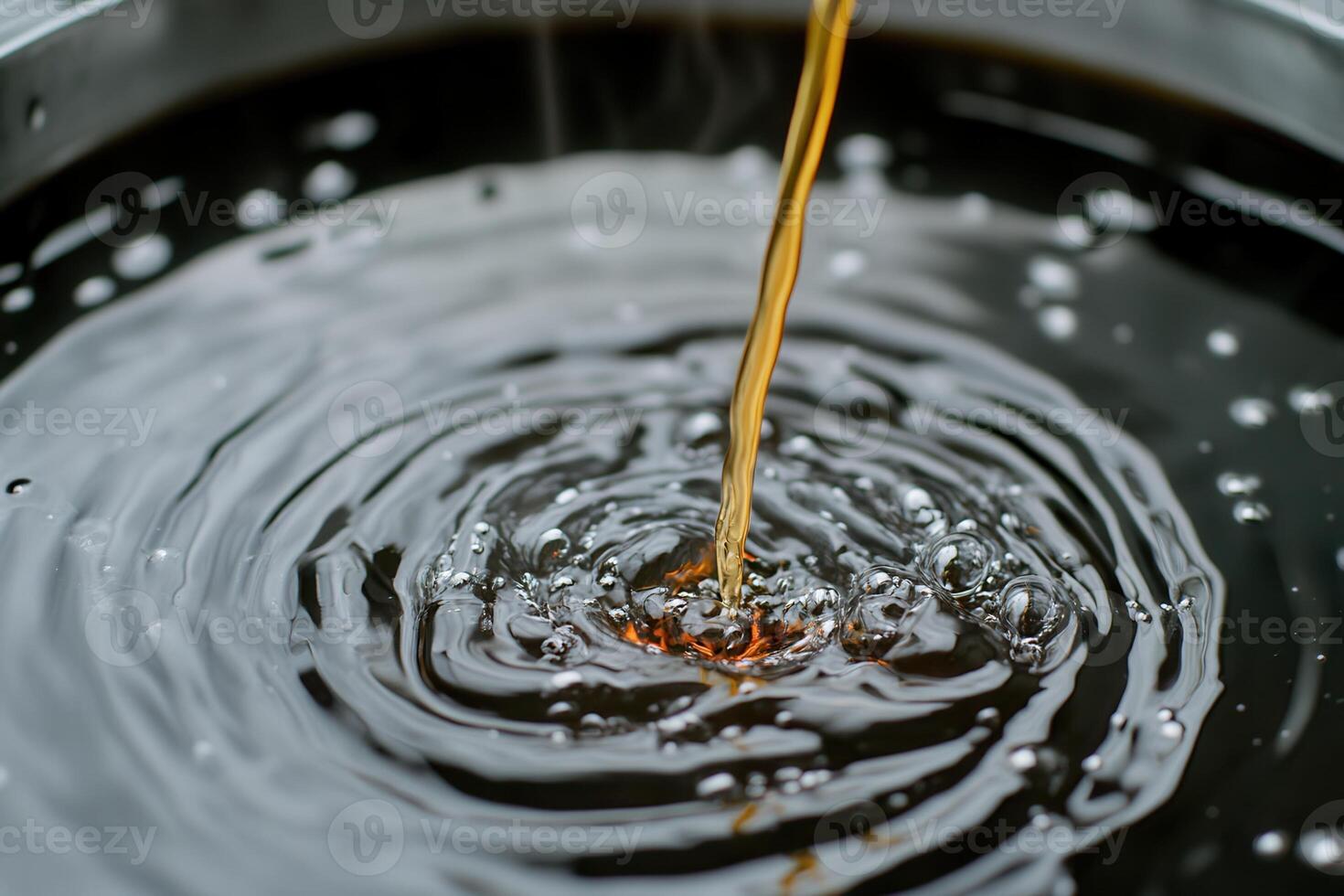 Liquid being poured into dark, rippling water surface. photo