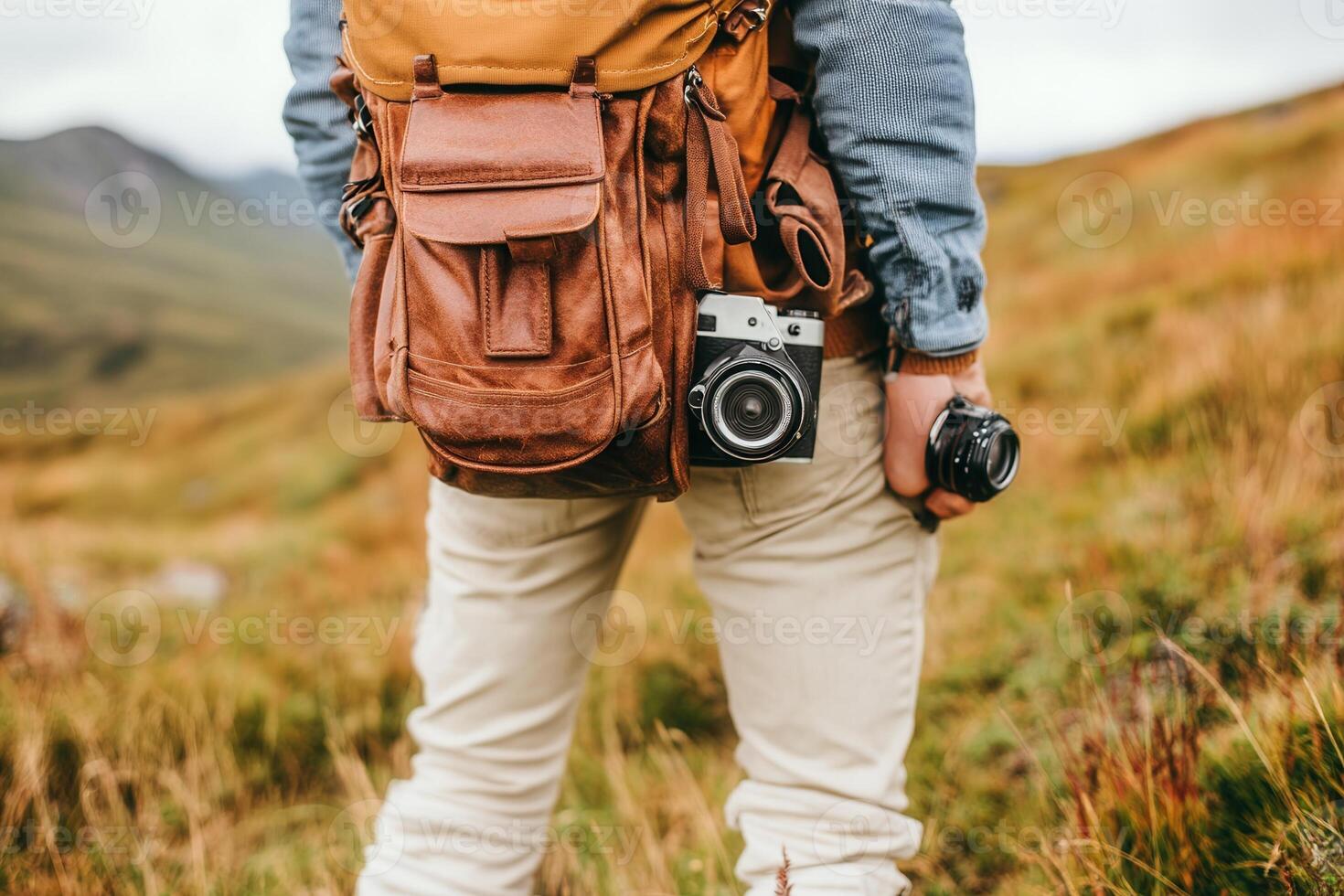 Person with cameras and a backpack in a natural setting. photo