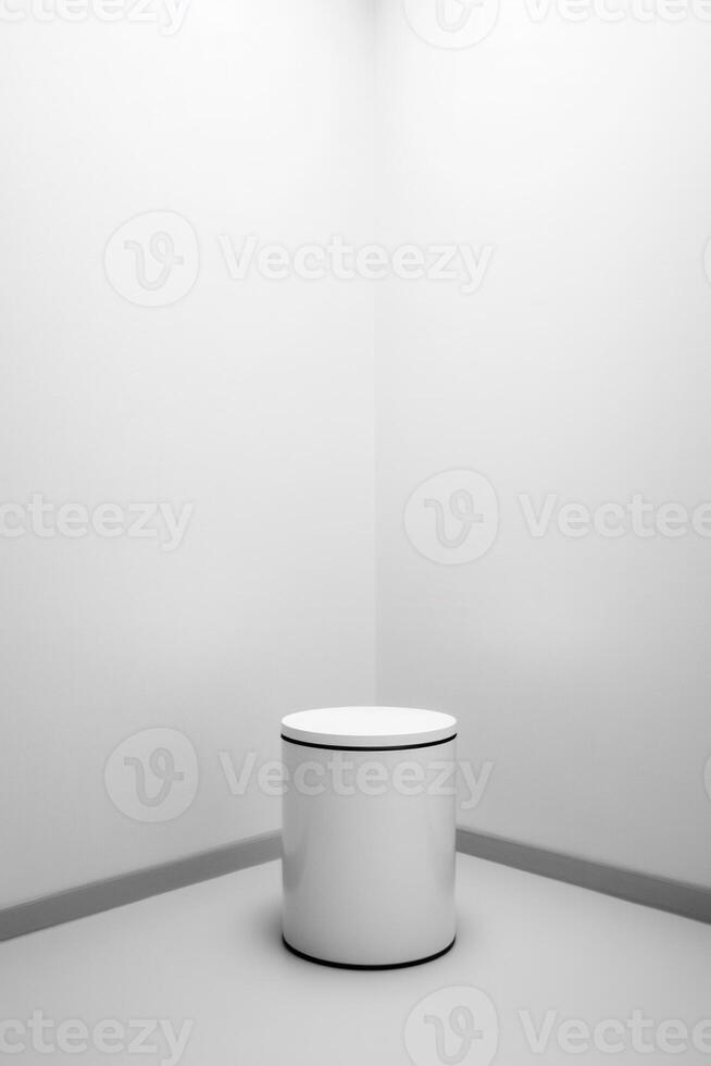 Empty white cylinder podium in corner photo