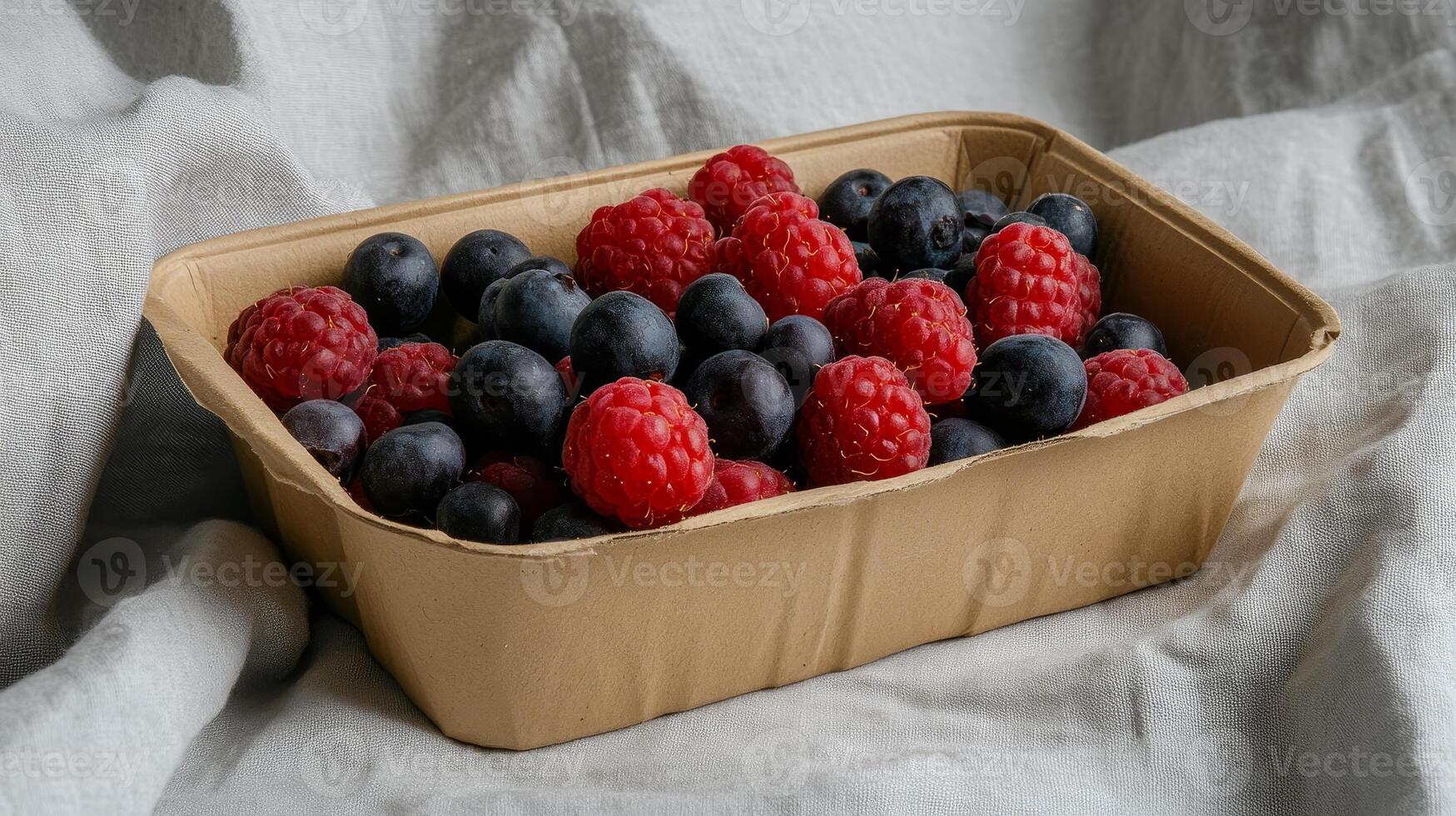 Fresh Raspberries and Blueberries in a Sustainable Paper Container photo