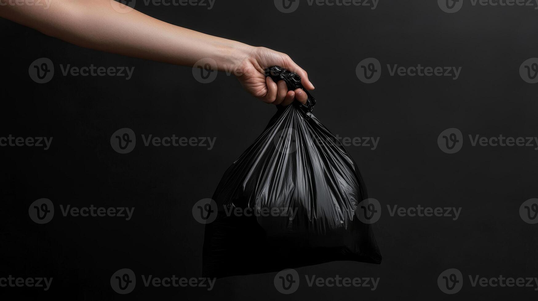 Hand Holding a Black Trash Bag - Environmental Responsibility photo