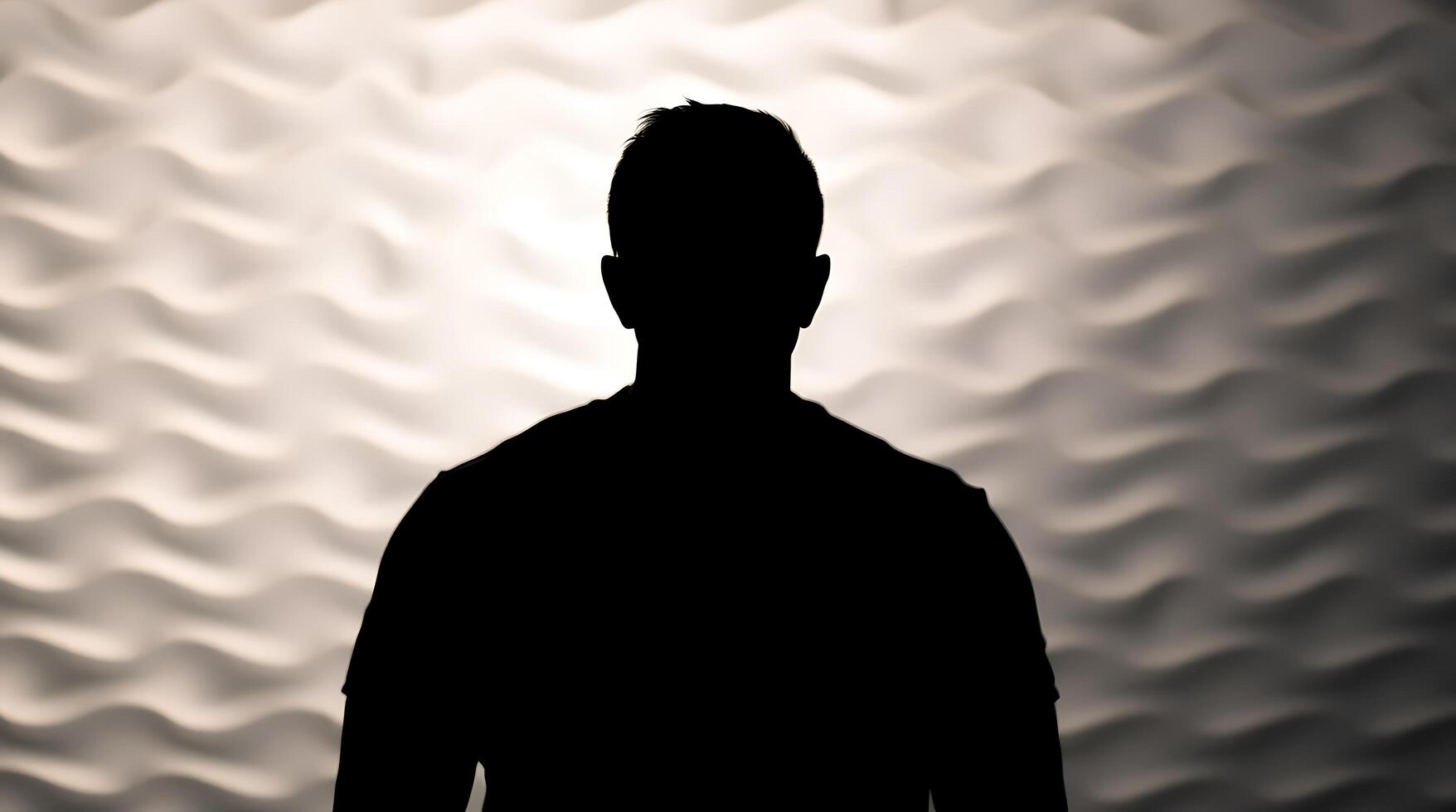 A silhouette of a man standing in front of a wall photo