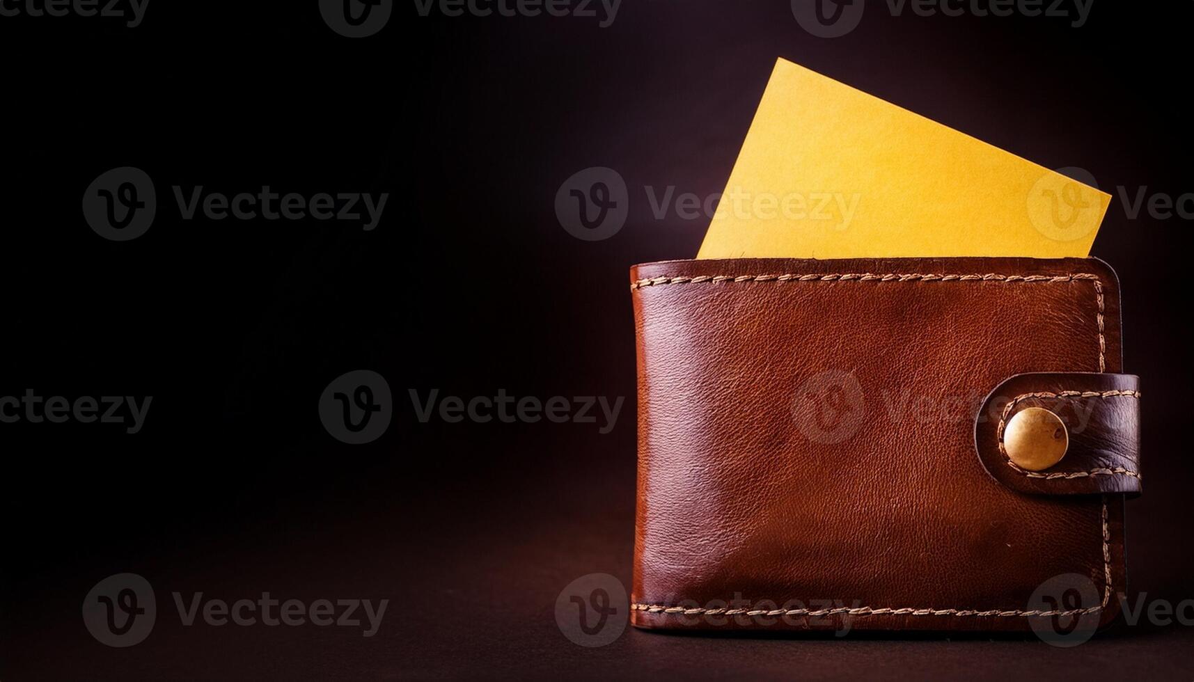 Brown Leather Wallet With a Yellow Card on a Dark Background During Evening photo