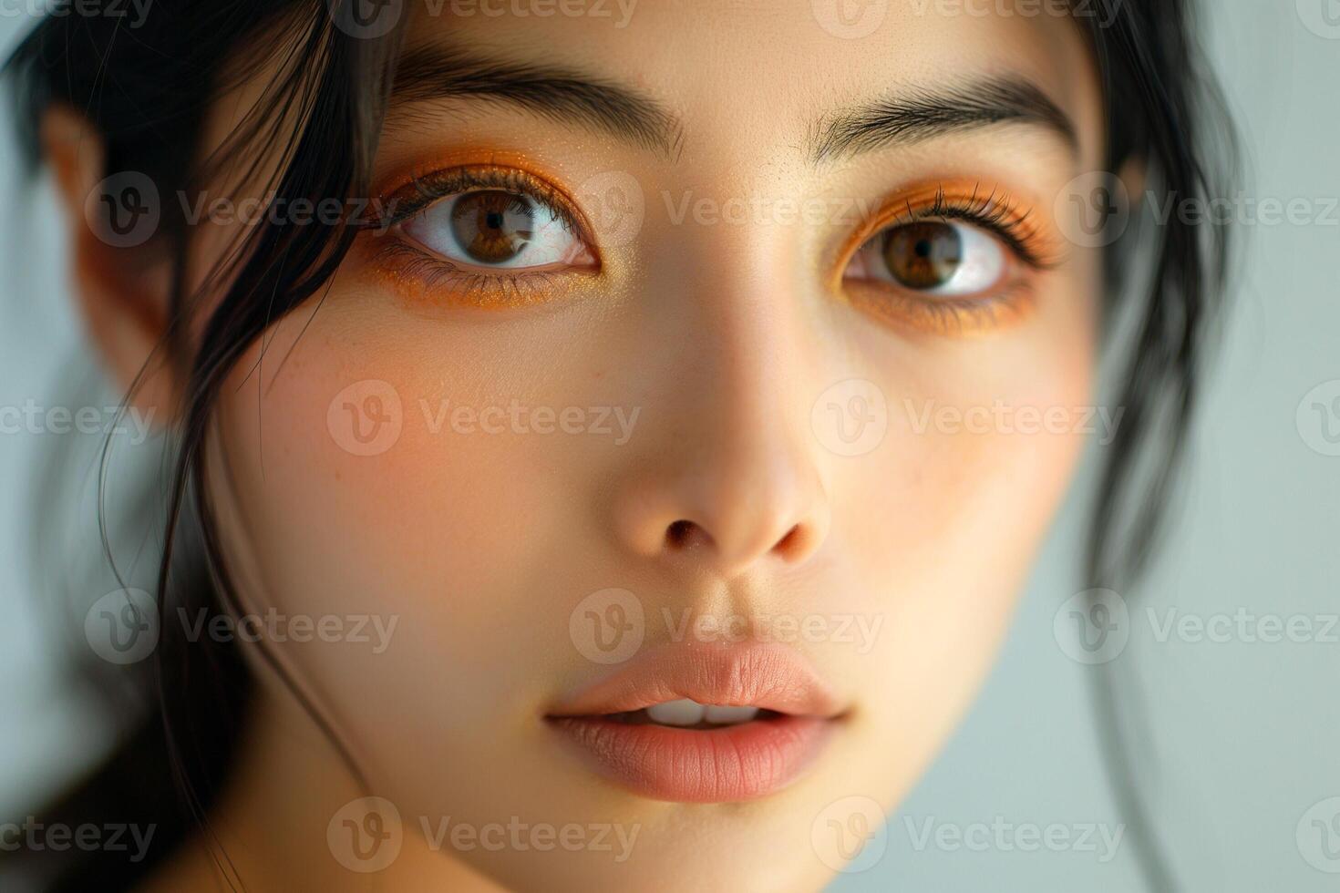 Portrait of a young Asian woman with striking orange eye makeup and soft features, exuding a serene and captivating vibe. photo