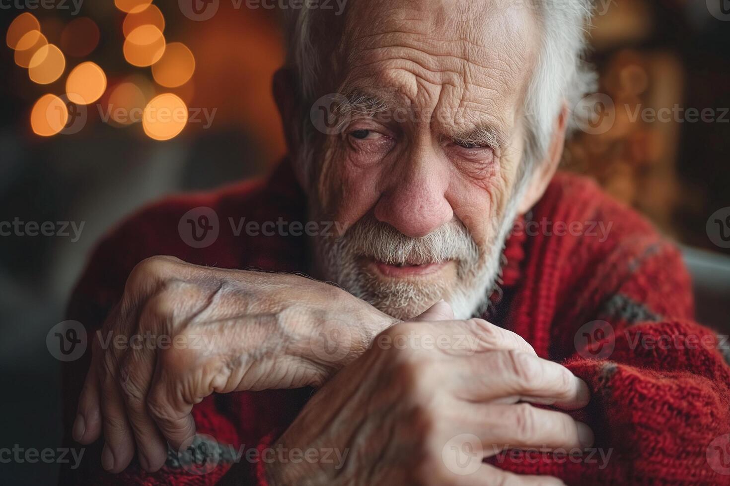An elderly Caucasian man in a cozy knit sweater looks thoughtfully into the distance, reflecting a sense of nostalgia and warmth. photo