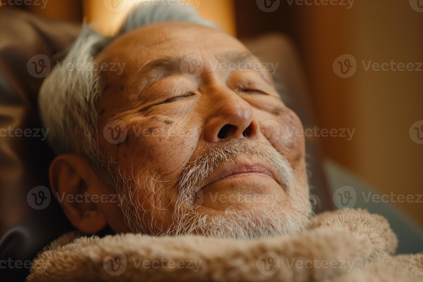 Close-up of an elderly Asian man peacefully relaxing with eyes closed in a cozy environment. photo