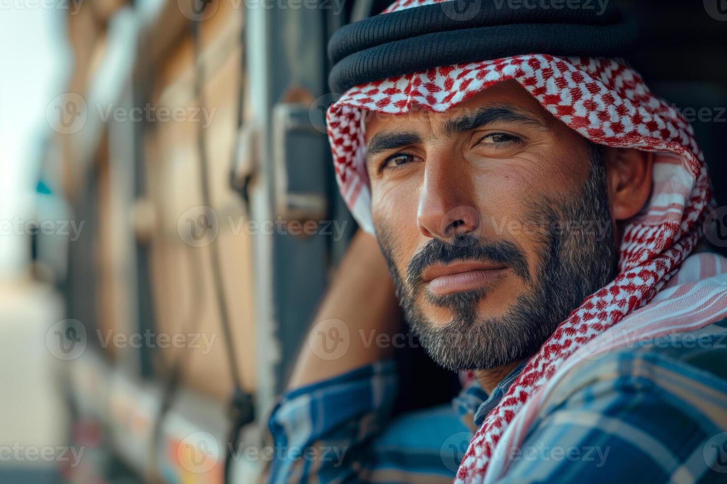A Middle-Eastern man in traditional attire leans against a vehicle, exuding confidence and contemplation. photo