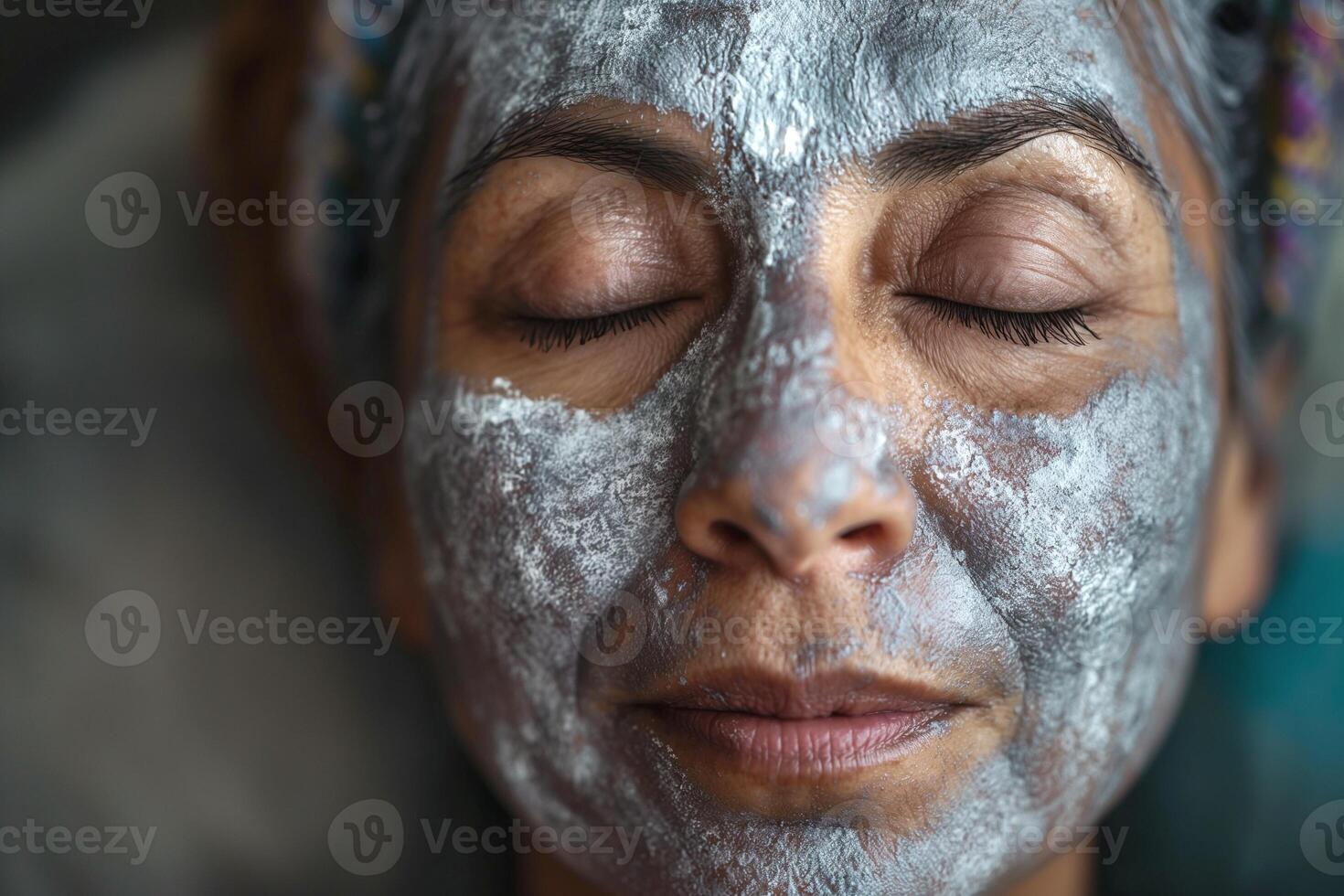 A serene woman of Latin heritage relaxes with a facial mask, her eyes closed, exuding tranquility and self-care. photo
