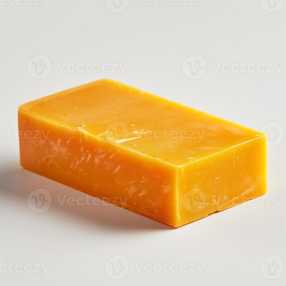 A vibrant yellow block of cheese, showcasing its smooth surface and rich color against a neutral background. photo