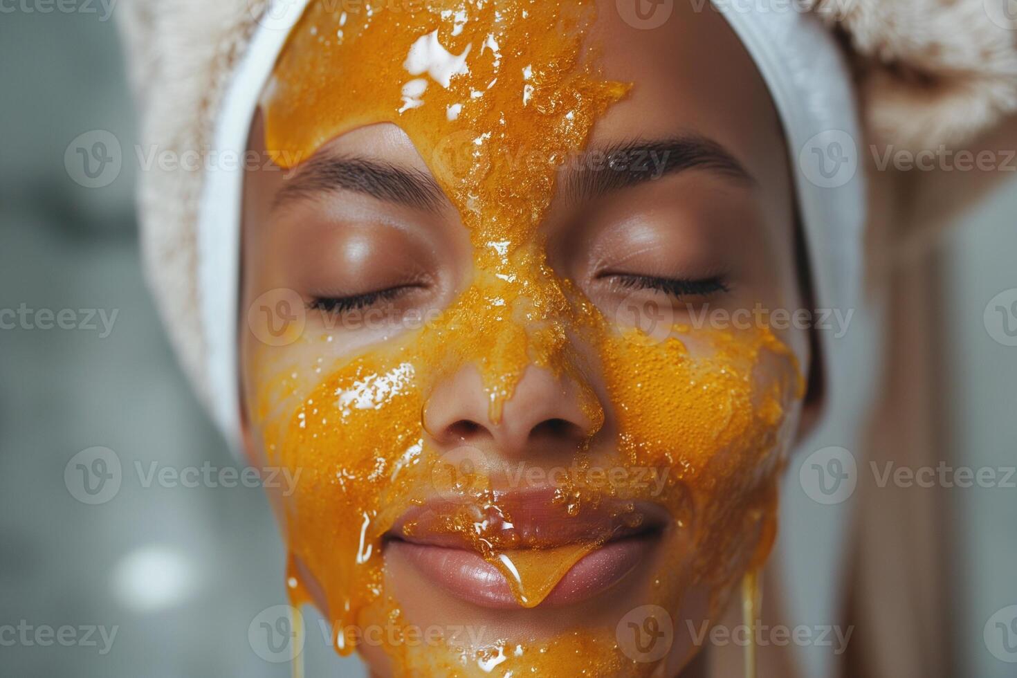 A young woman of mixed ethnicity relaxes with a honey mask on her face, showcasing radiant skin and a serene expression. photo