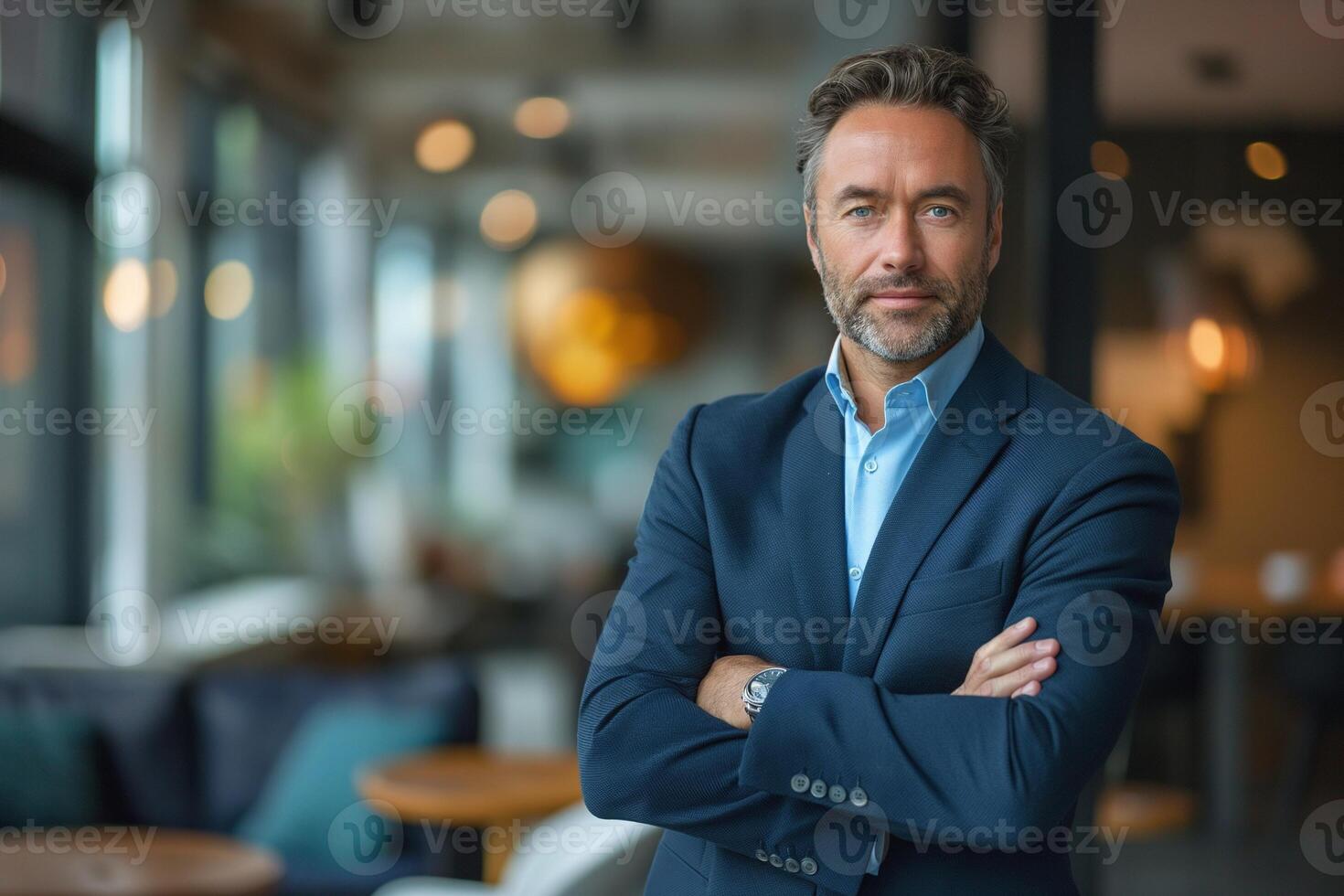 Confident middle-aged man with salt-and-pepper hair poses in a modern interior, exuding professionalism and charisma. photo